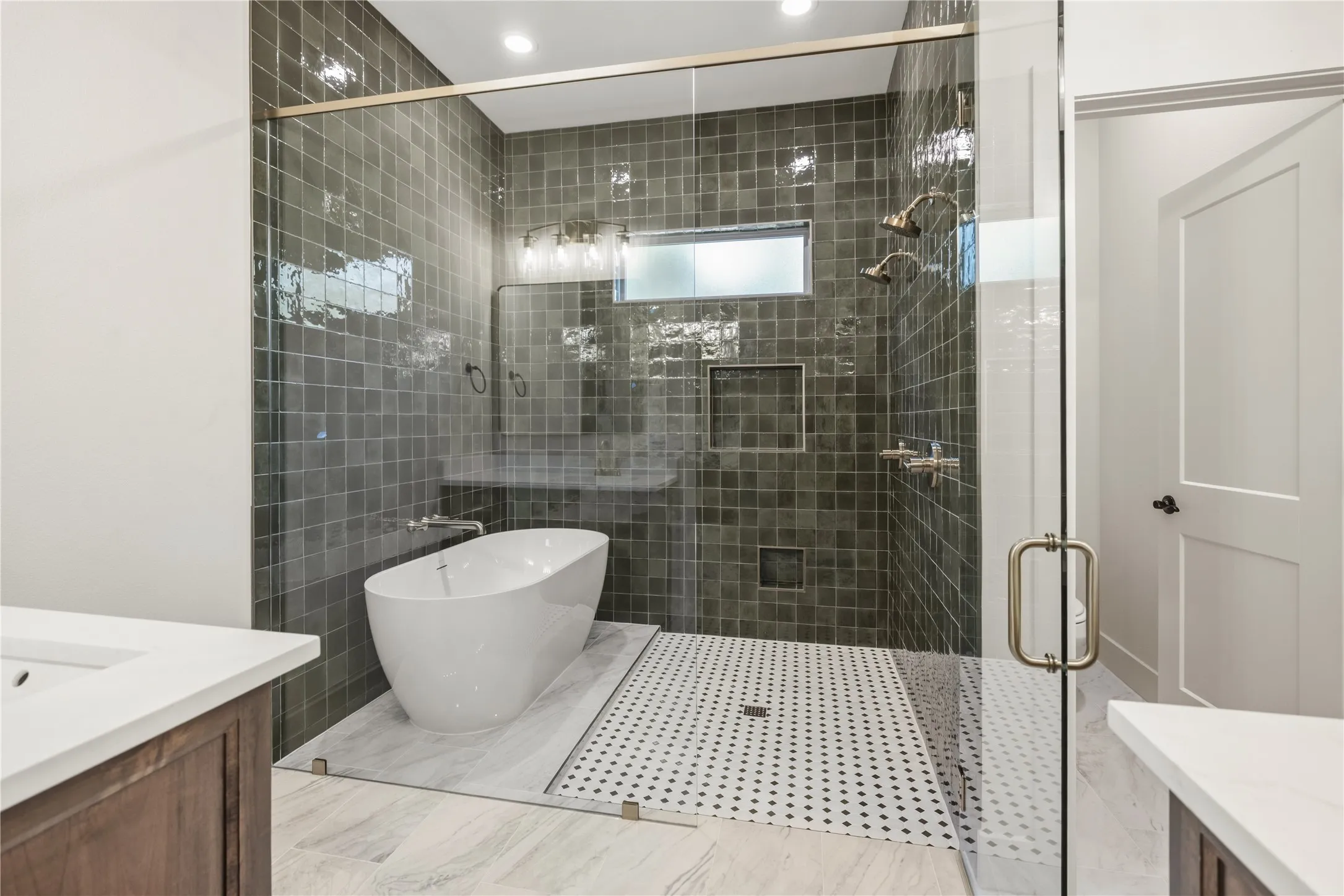 Glass-enclosed shower with dark square tile, dual shower heads, and an integrated freestanding tub