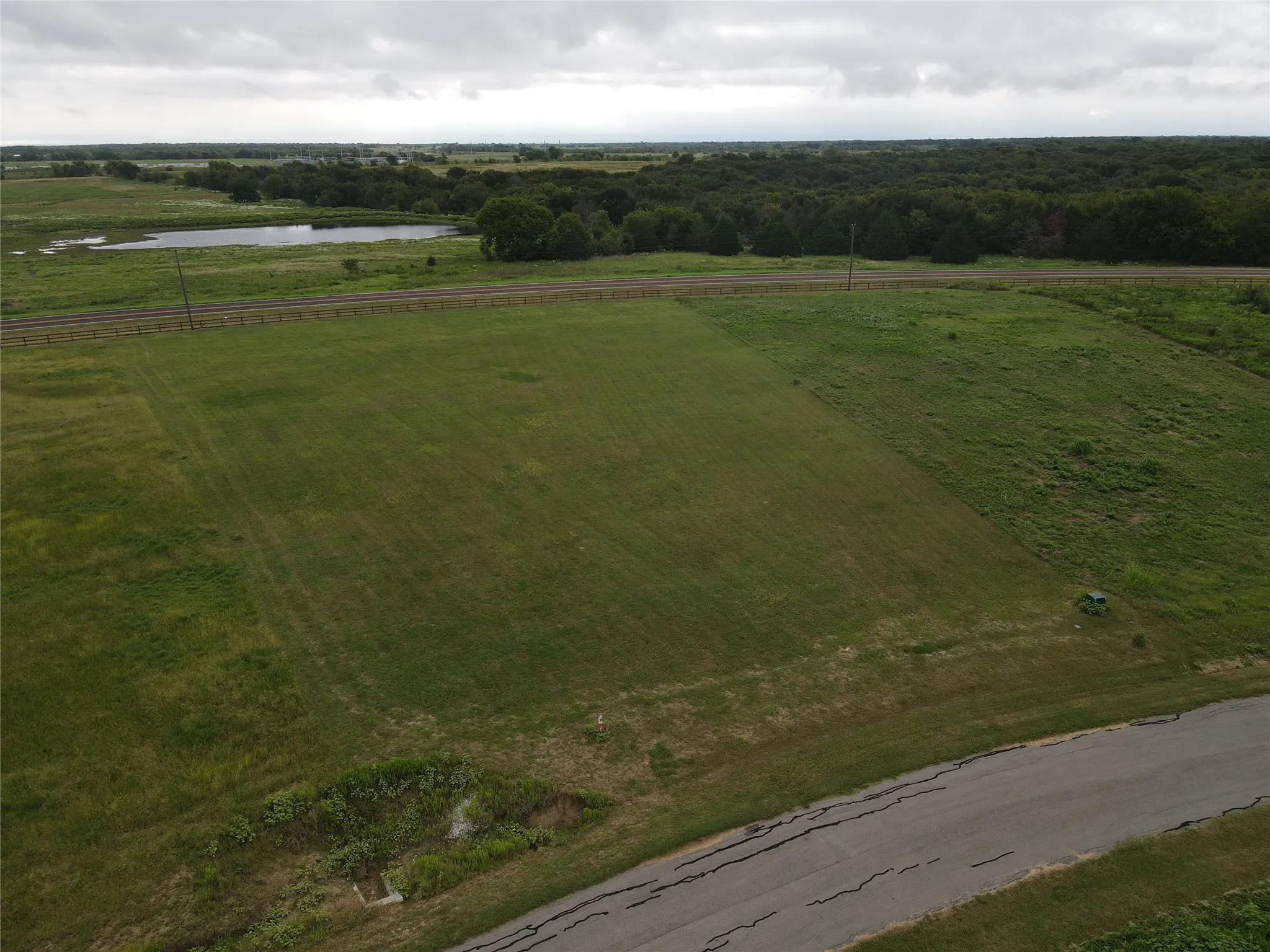 Expansive green space with an asphalt road frontage