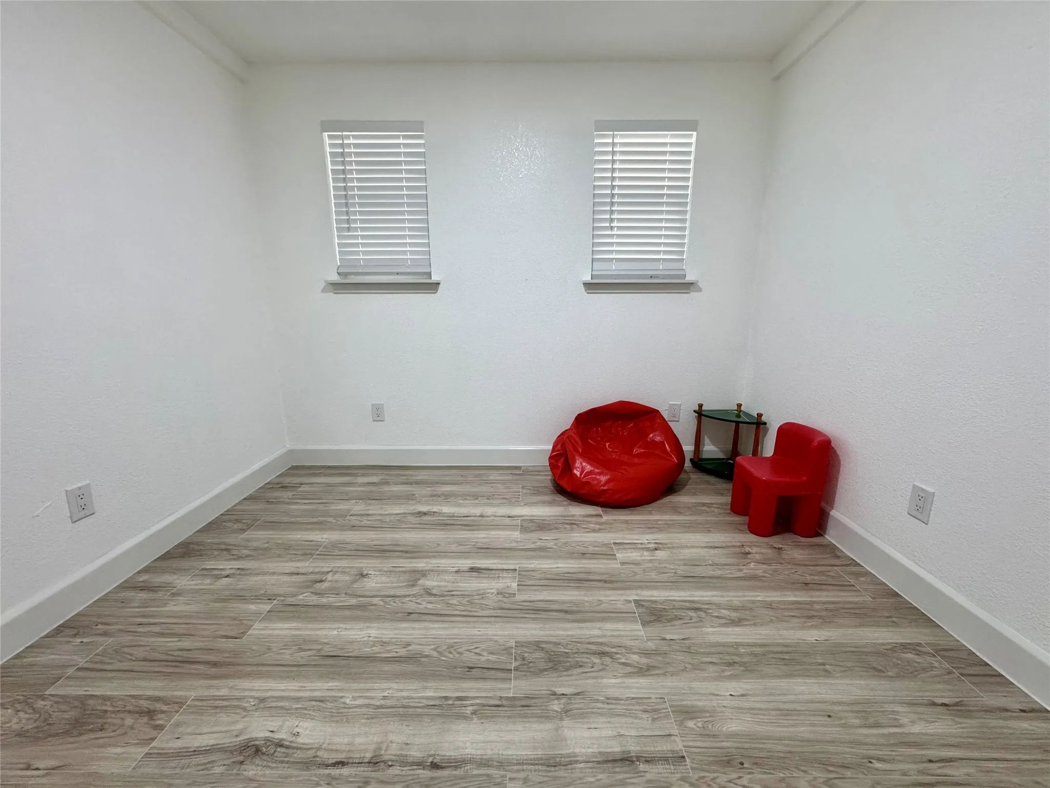 Unfurnished room with wood finished floors and baseboards