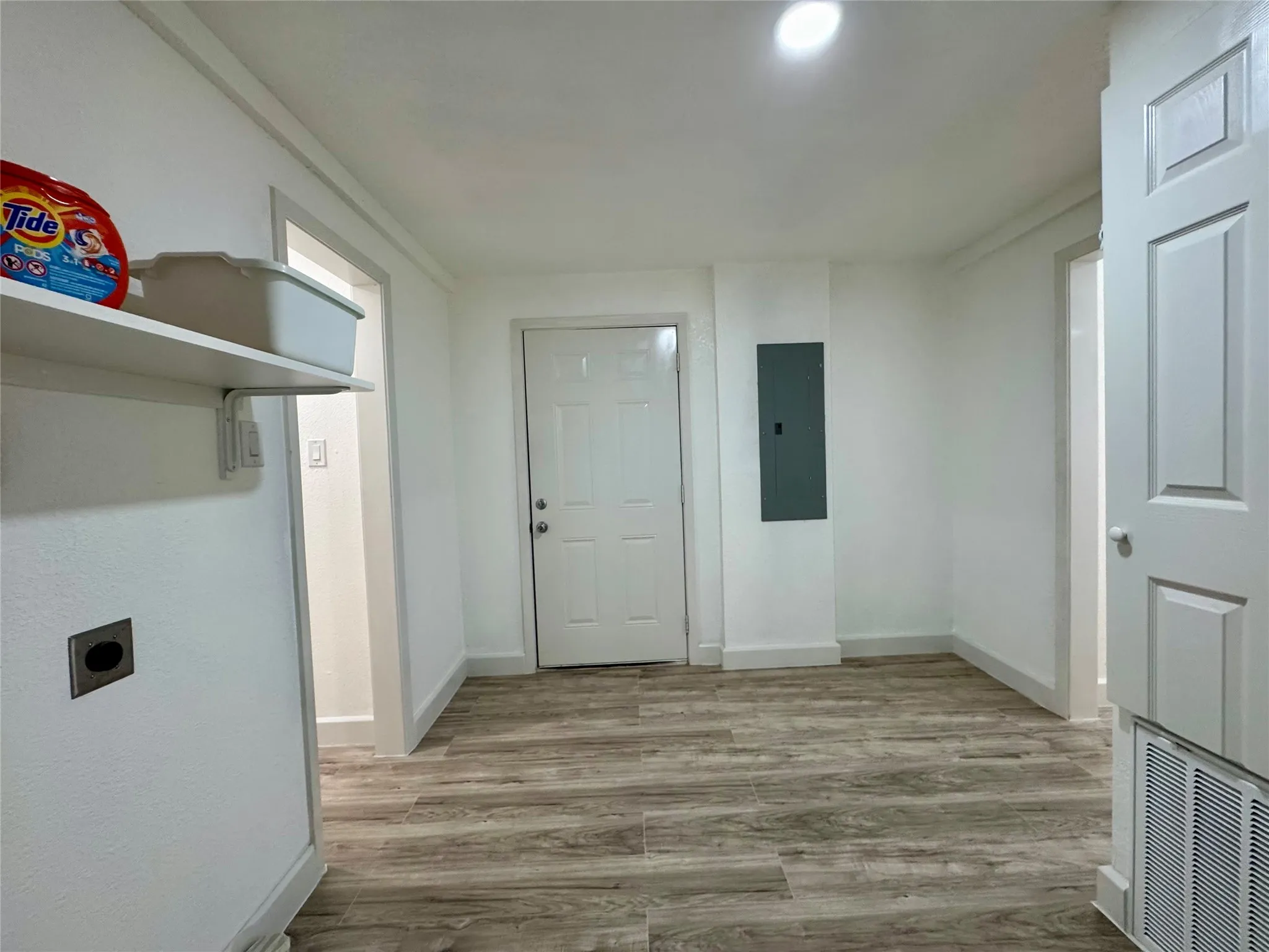 Laundry area featuring electric panel, hookup for an electric dryer, and wood finished floors