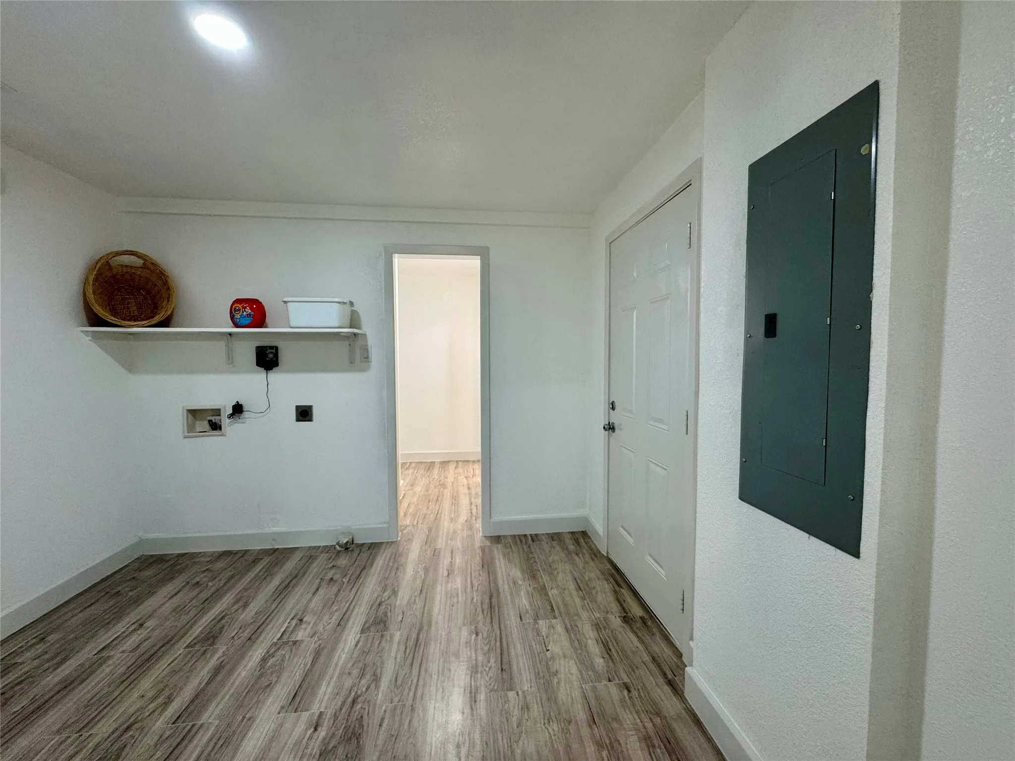 Laundry room with electric panel, wood finished floors, hookup for an electric dryer, and washer hookup