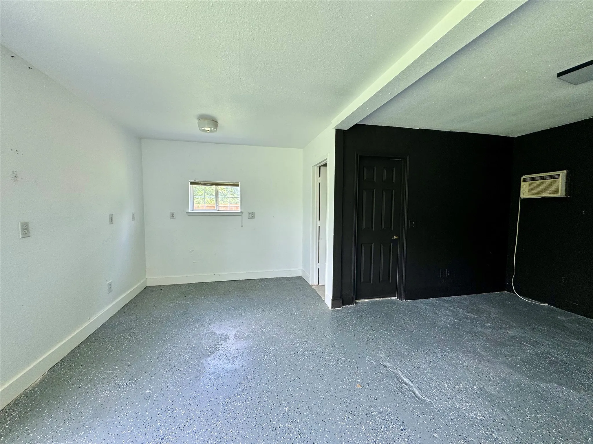 Spare room featuring a textured ceiling and a wall mounted air conditioner