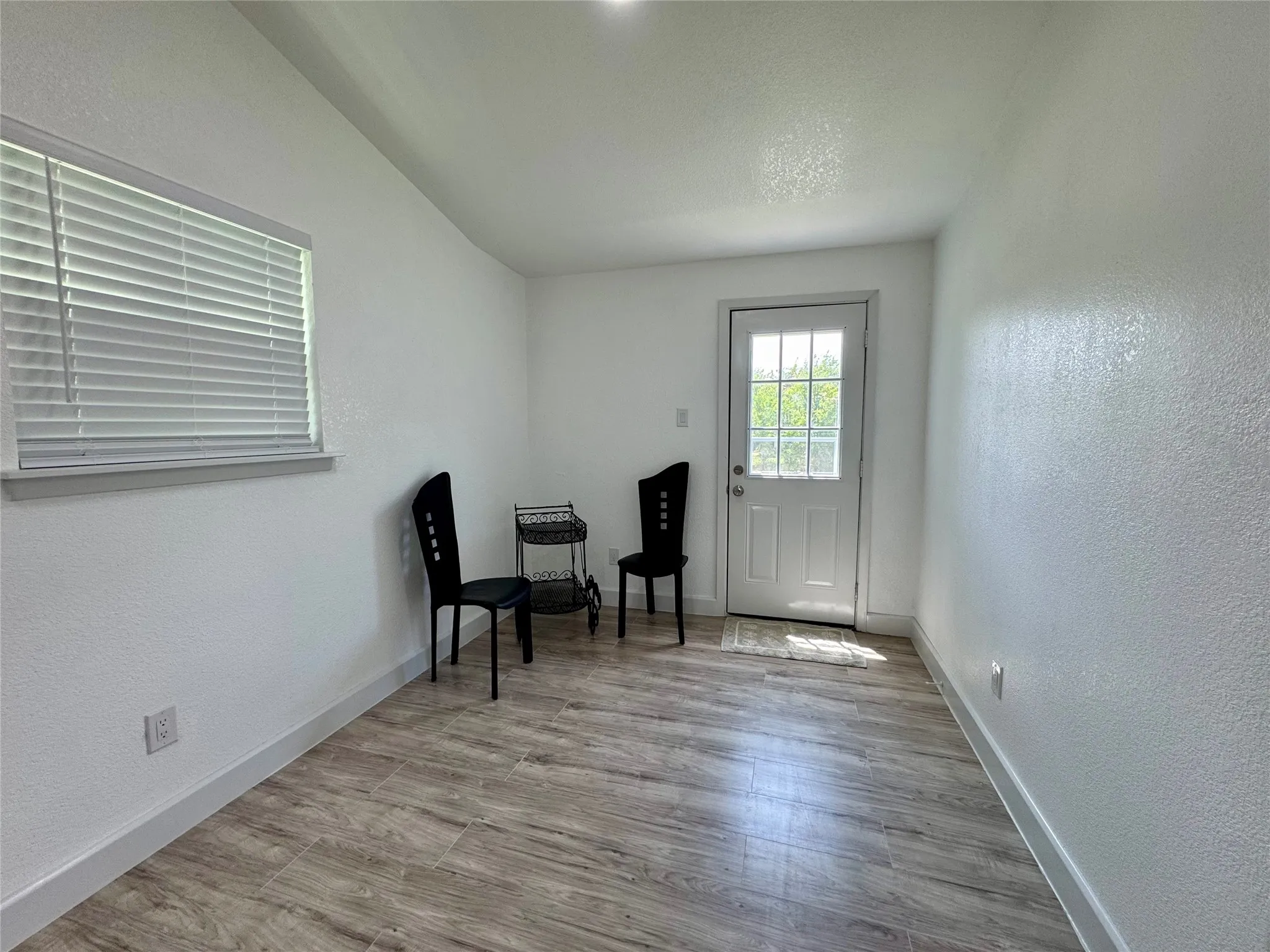 Sitting room featuring a textured wall and wood finished floors