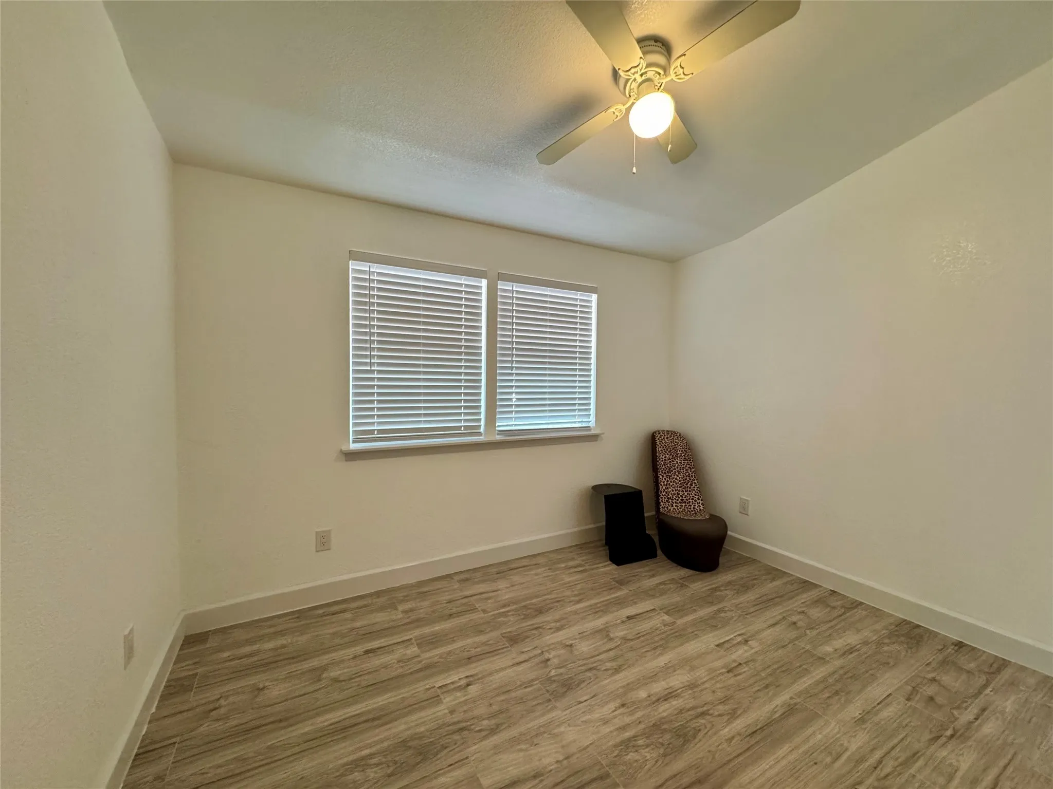 Spare room featuring wood finished floors and a ceiling fan