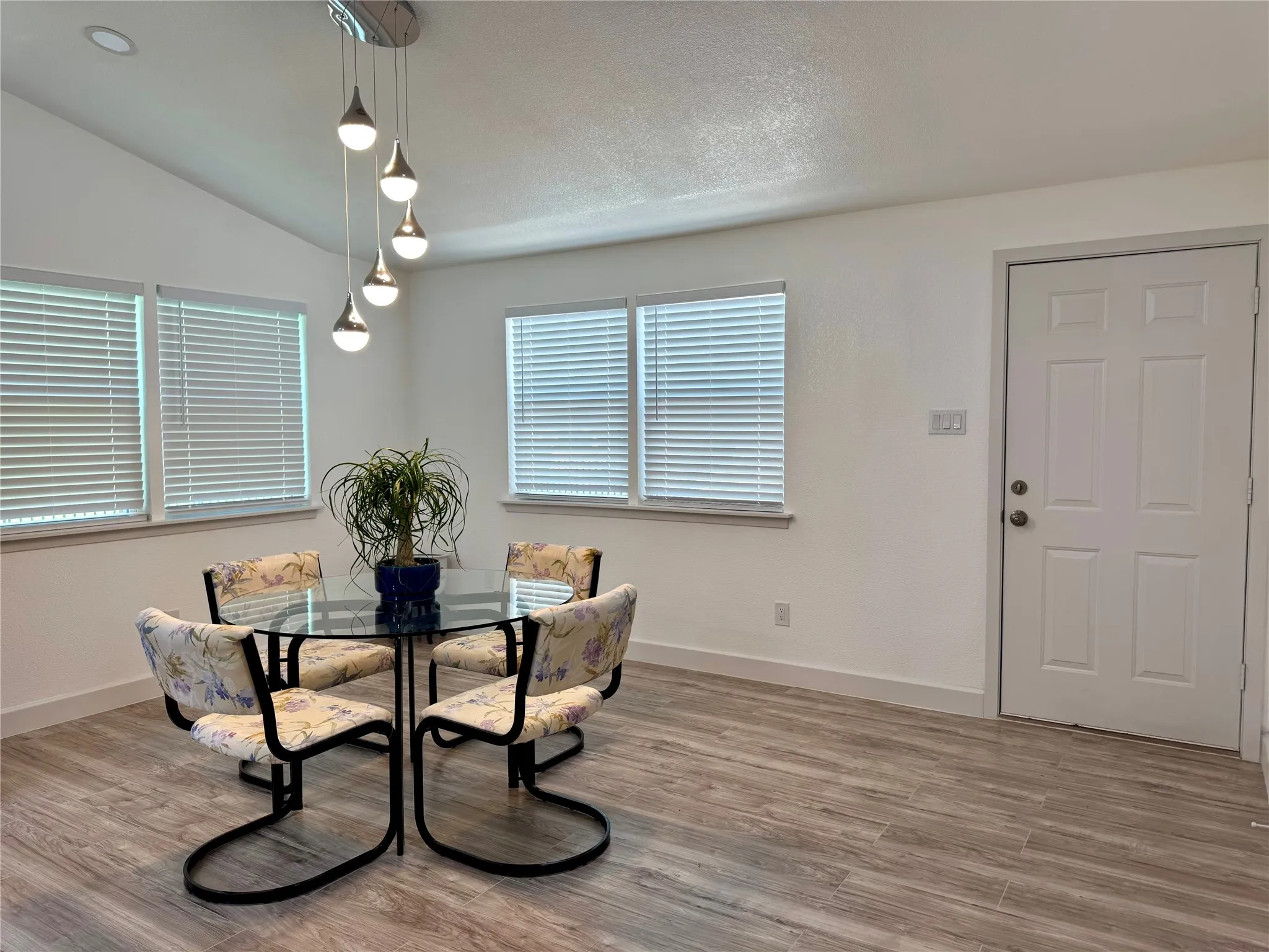 Dining space with wood finished floors and vaulted ceiling