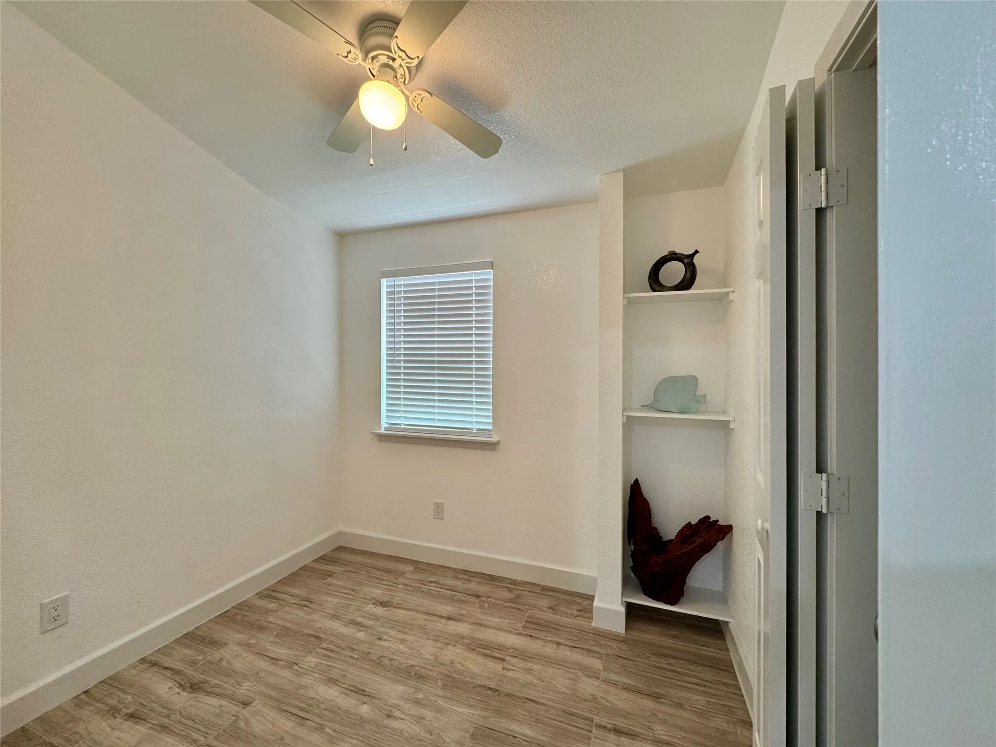 Unfurnished bedroom featuring wood finished floors and ceiling fan