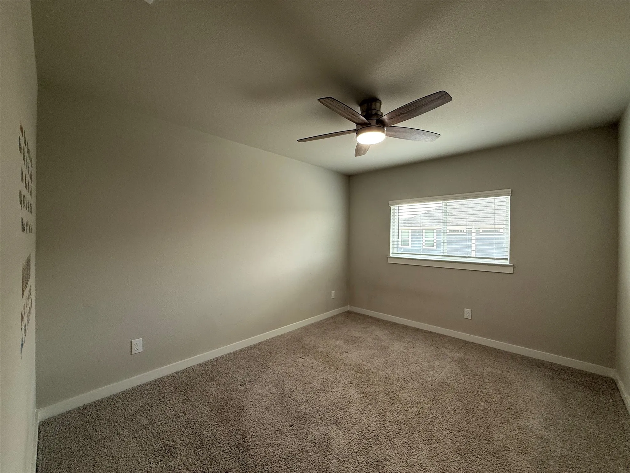 Neutral wall paint, ceiling fan with integrated lighting, carpeted flooring, and window with blinds