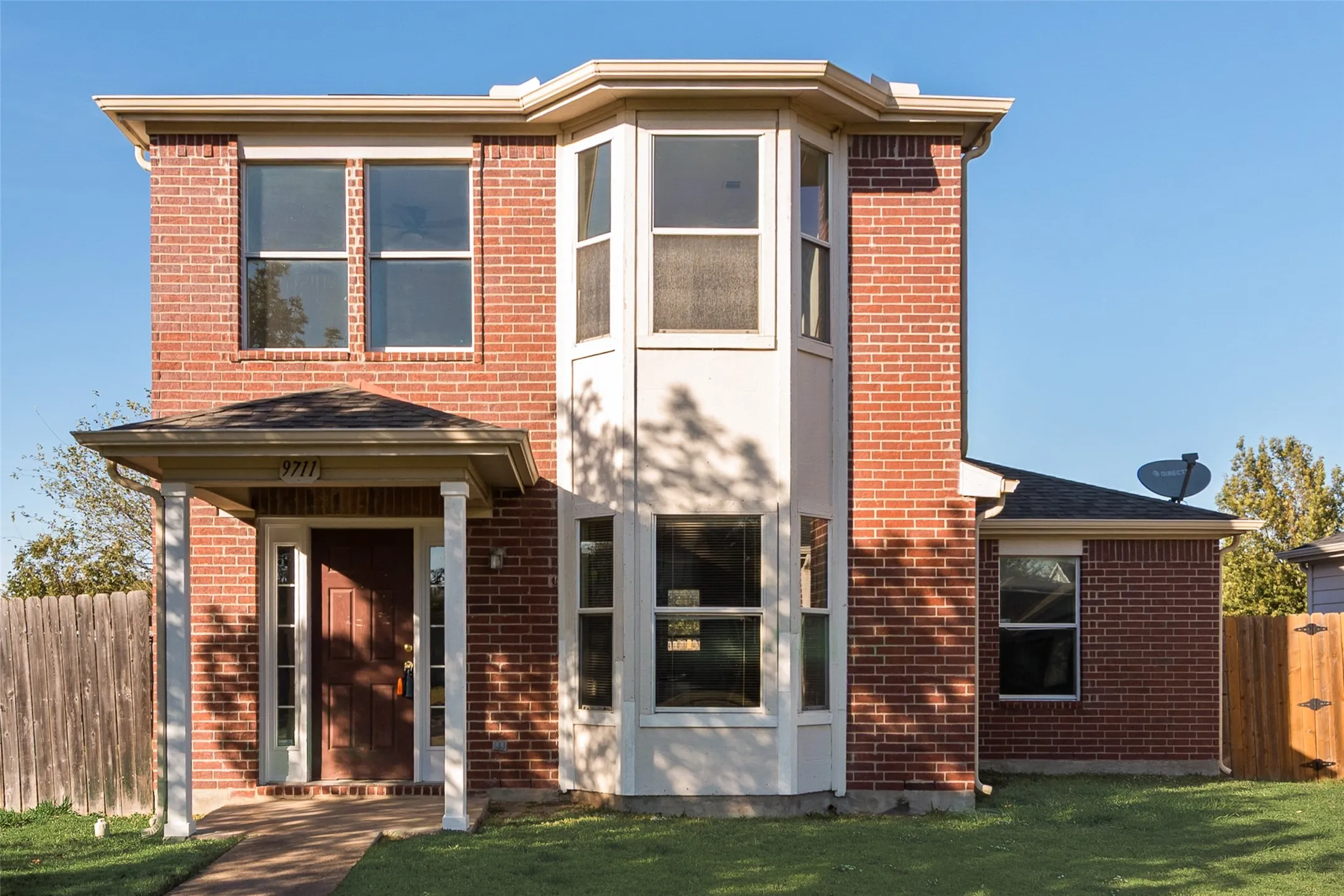 Brick exterior with a prominent bay window, covered entry, and pitched rooflines