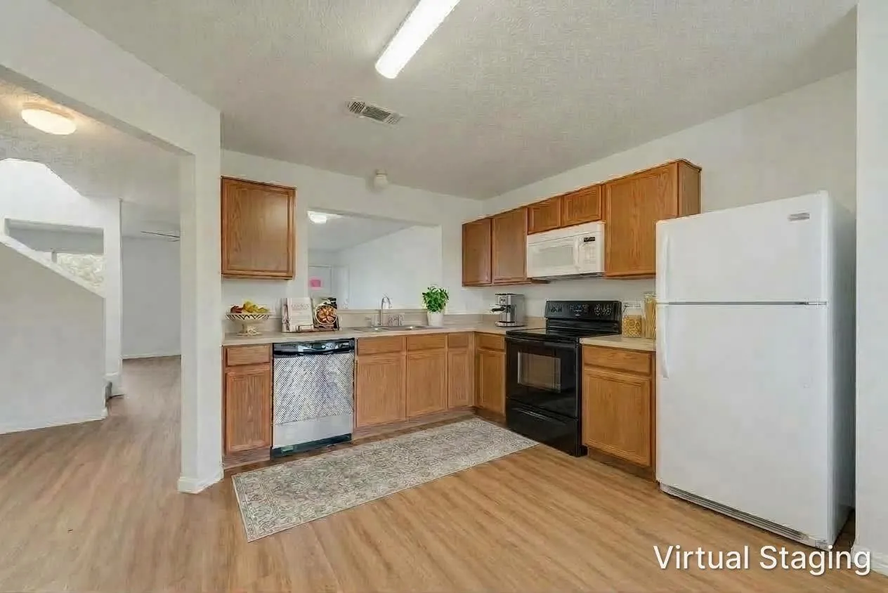 Kitchen featuring wood-finish flooring, wood cabinetry, white appliances, and a stainless steel dishwasher