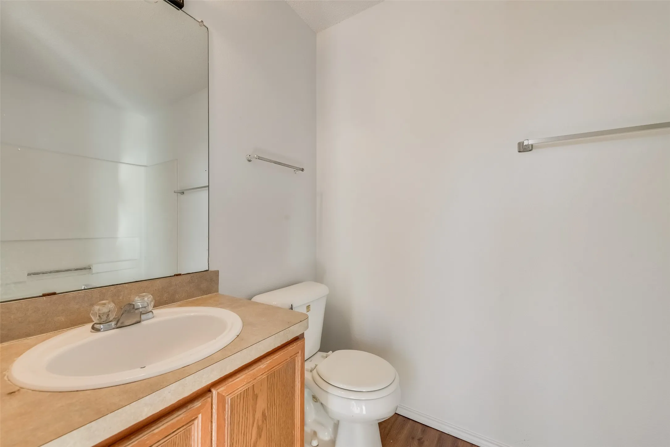 Vanity with wood-finish cabinetry, solid surface countertop, and integral sink