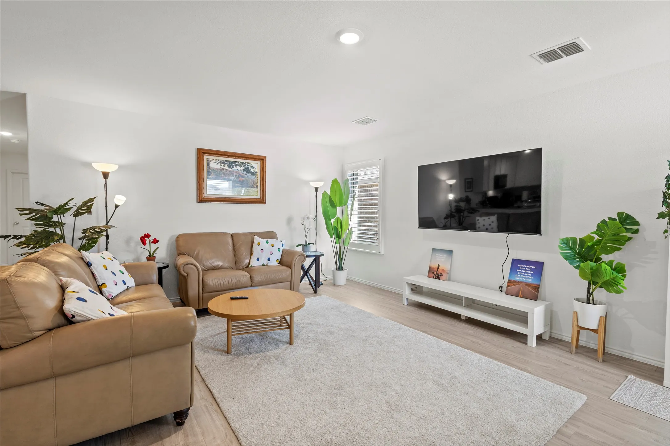 Light-toned wood-finish flooring, recessed ceiling lighting, and a window with white louvered blinds