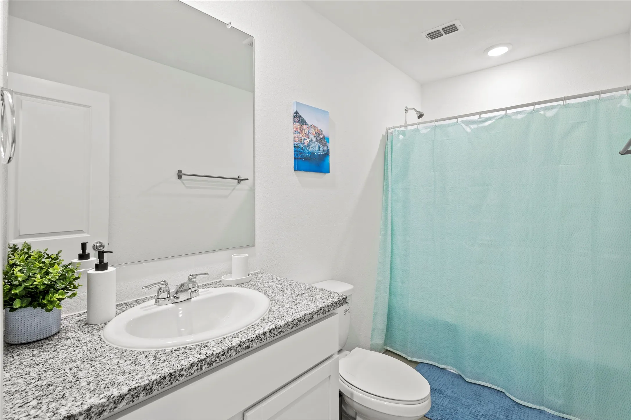 Bathroom with an integral sink, chrome faucet, granite-patterned countertop, and an overhead shower fixture