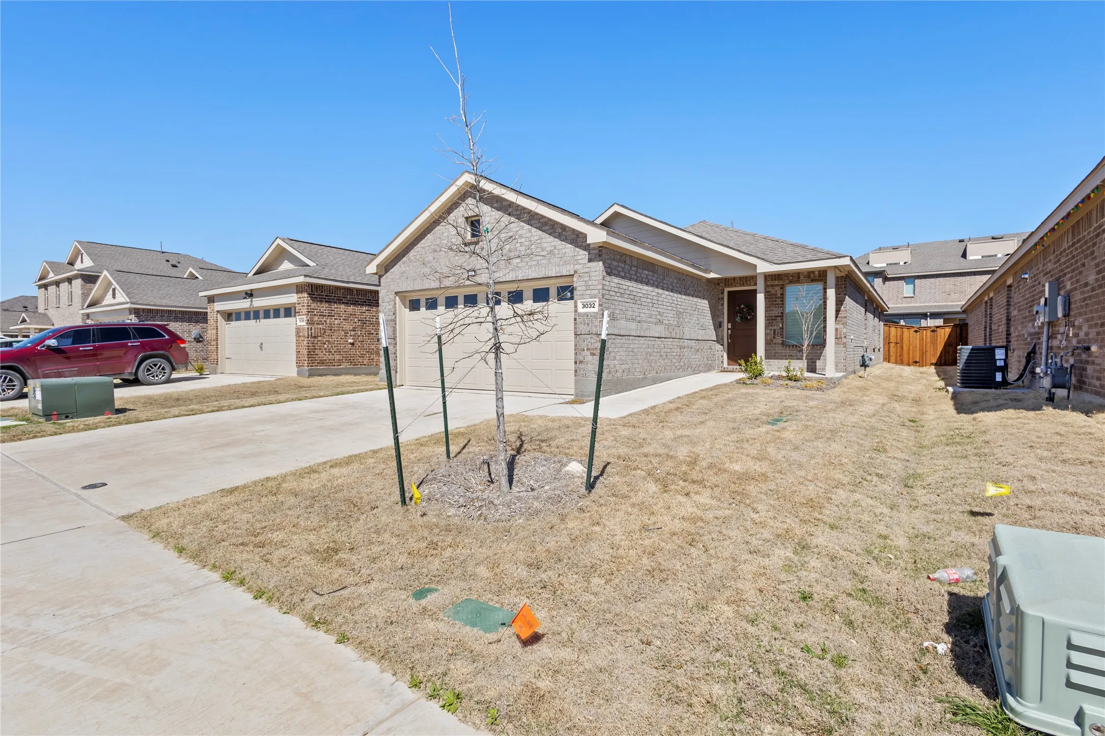 Brick veneer exterior with an attached garage, covered entryway, and a concrete driveway