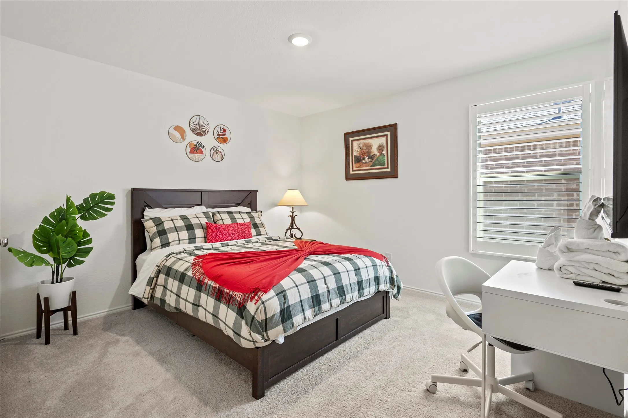 Recessed ceiling lighting, window with plantation shutters, light-toned carpeting, and a built-in closet with dark wood-finish doors