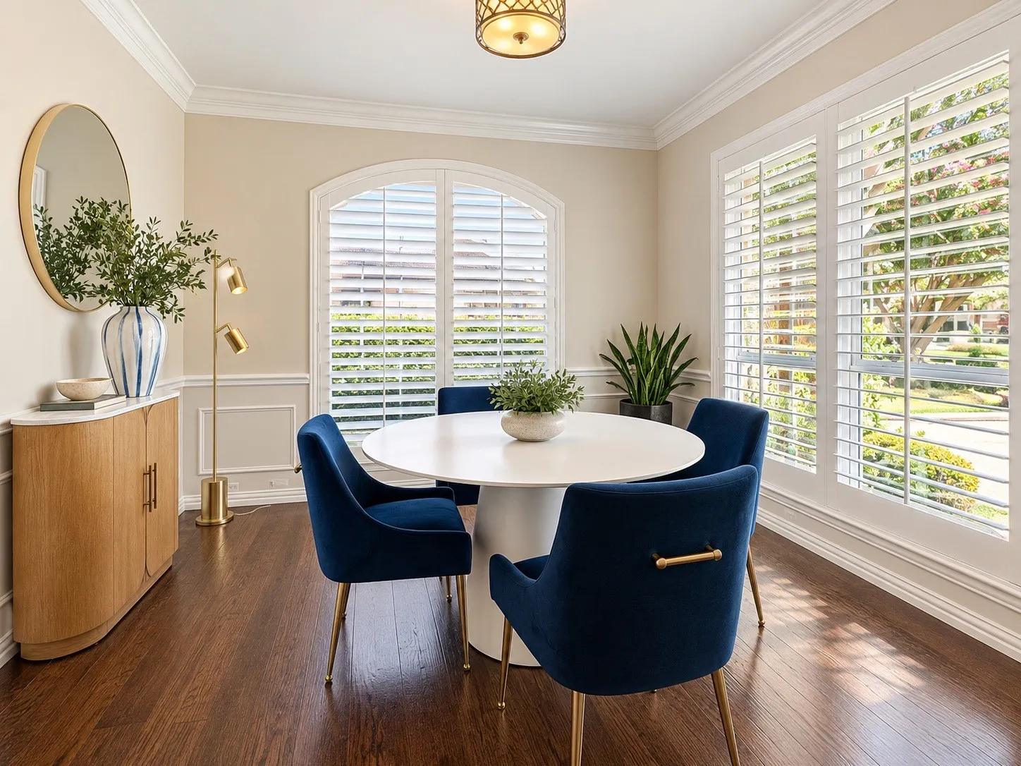 Wood-finish flooring, white crown molding, and plantation shutters