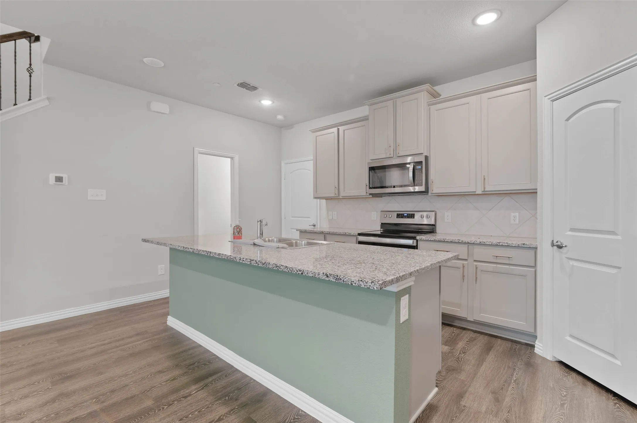 Kitchen with walk in pantry and doorway to the garage and a powder room.