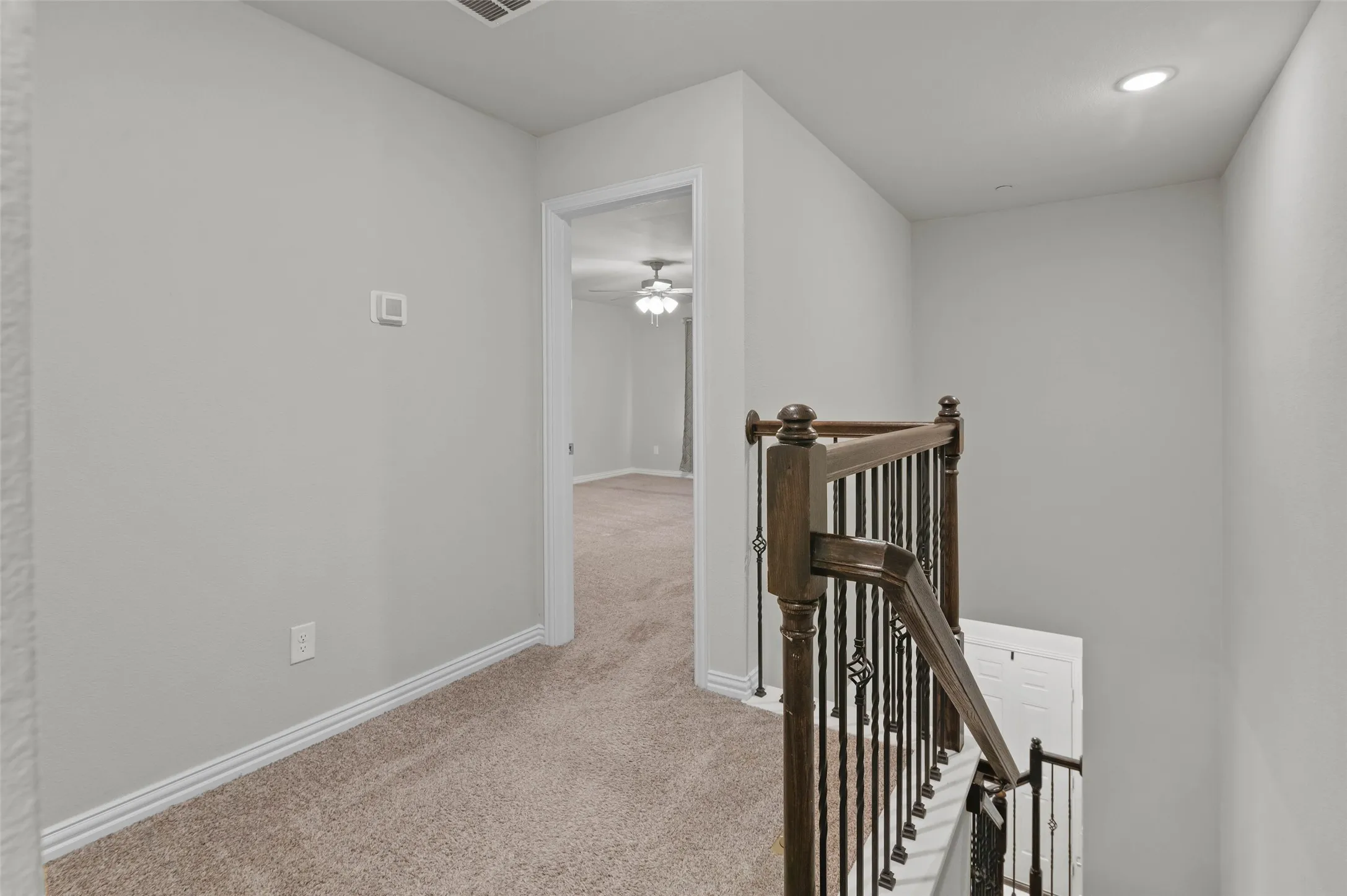 Landing at the top of the stairs and entry into the primary bedroom