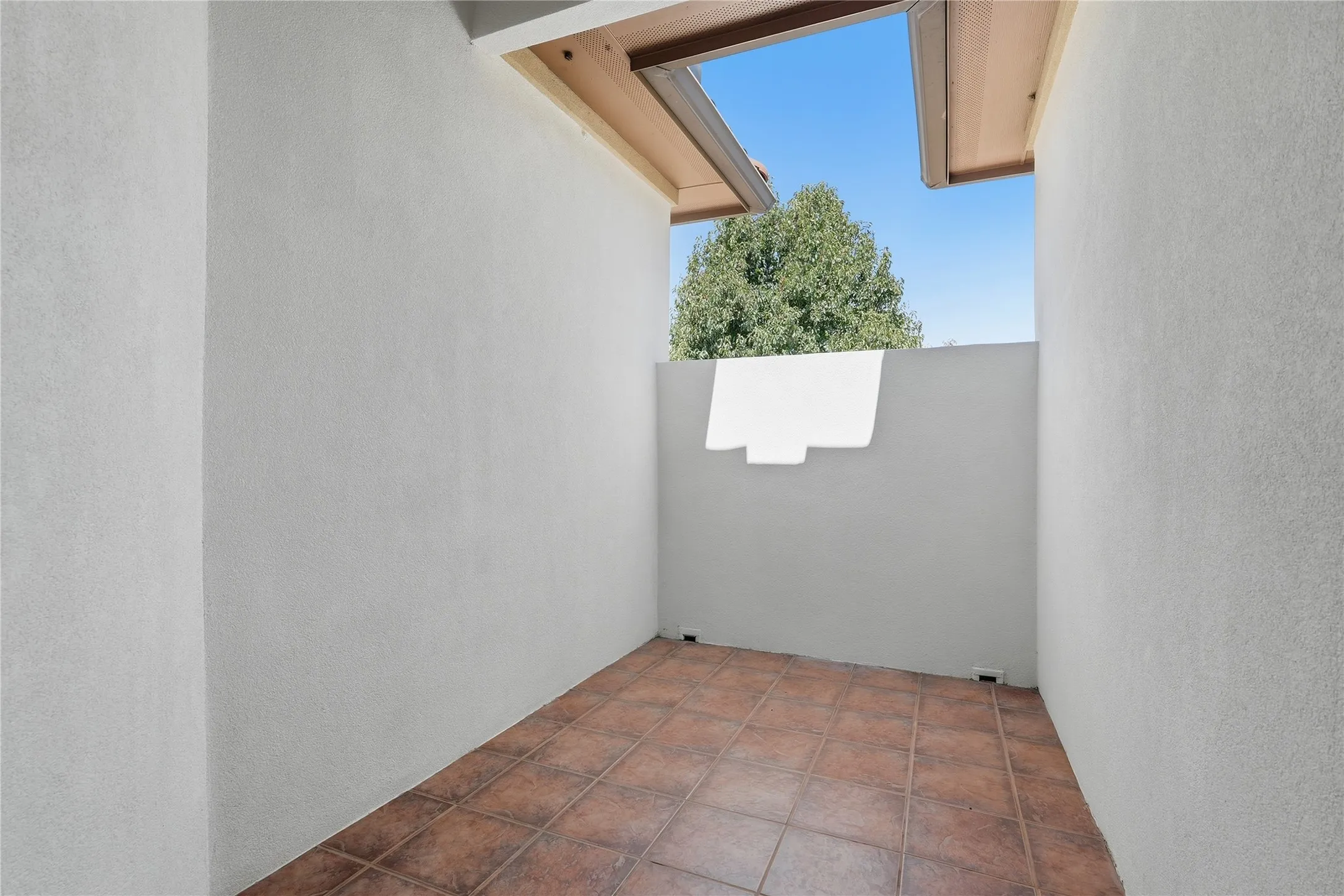 Private outdoor space with tile flooring and stucco walls