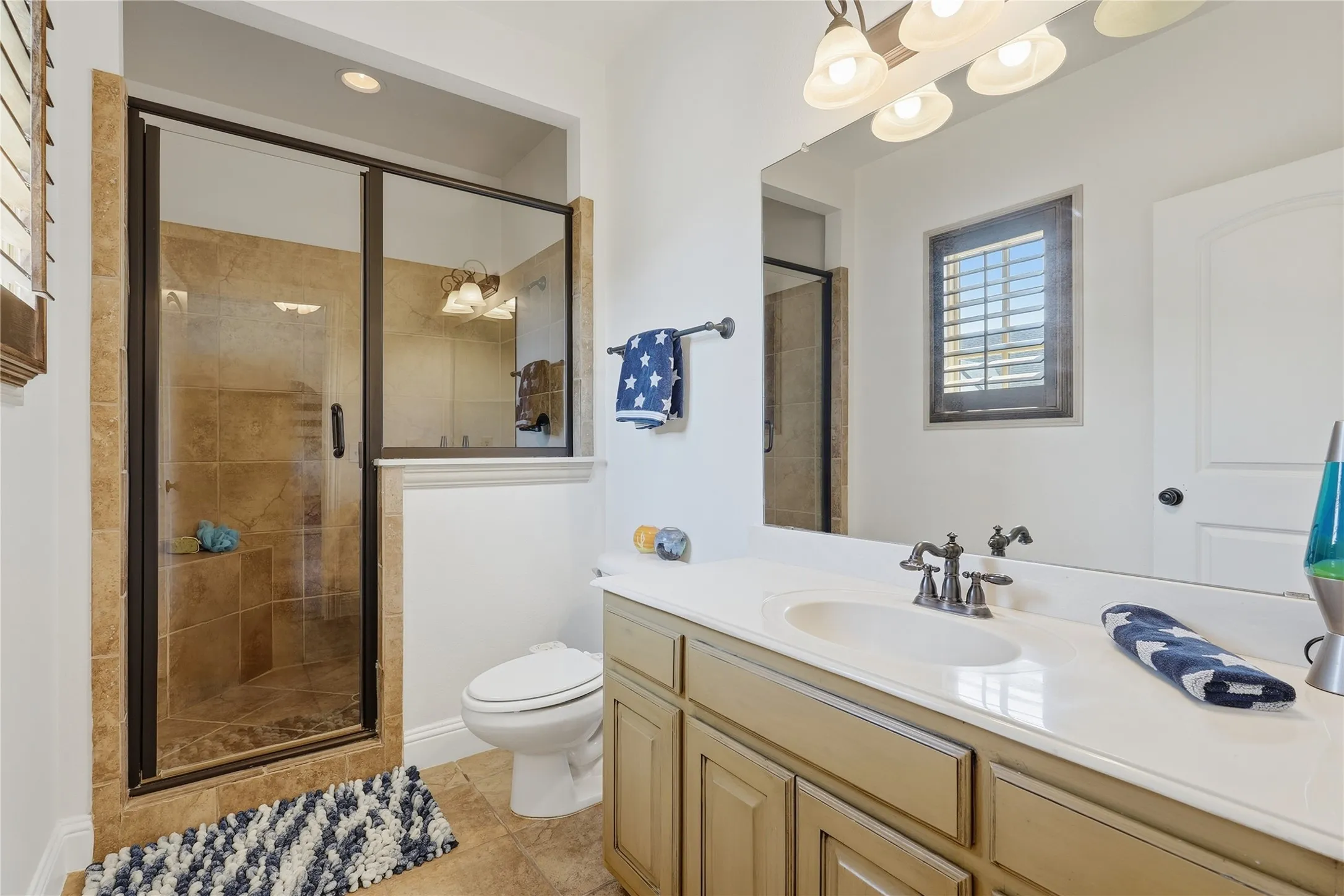 Glass-enclosed shower with tile surround and built-in bench