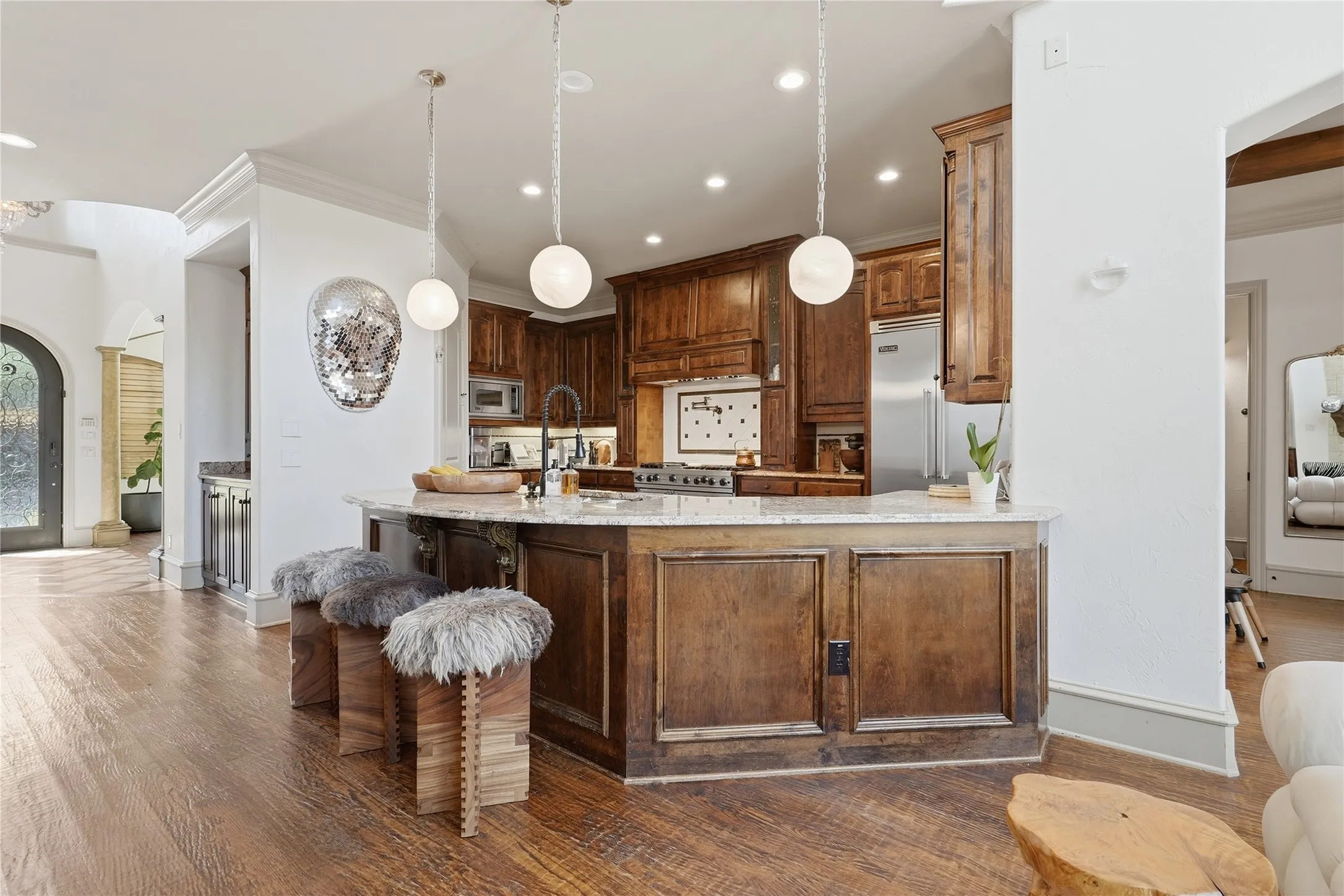 Gourmet kitchen with wood cabinetry, stainless steel appliances, and a central island with a light-colored countertop