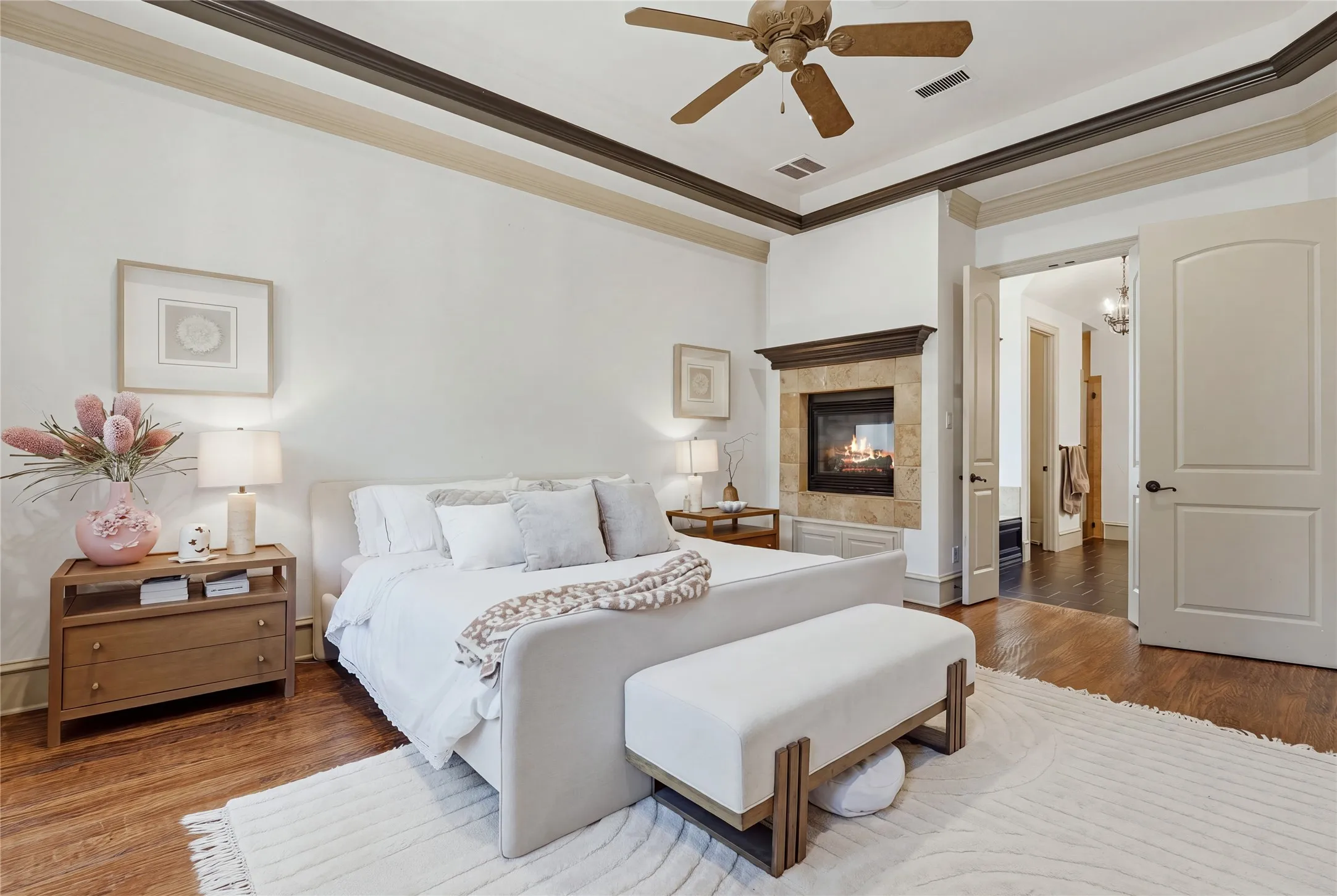 Hardwood flooring, recessed lighting, ceiling fan, fireplace with stone surround, and crown molding