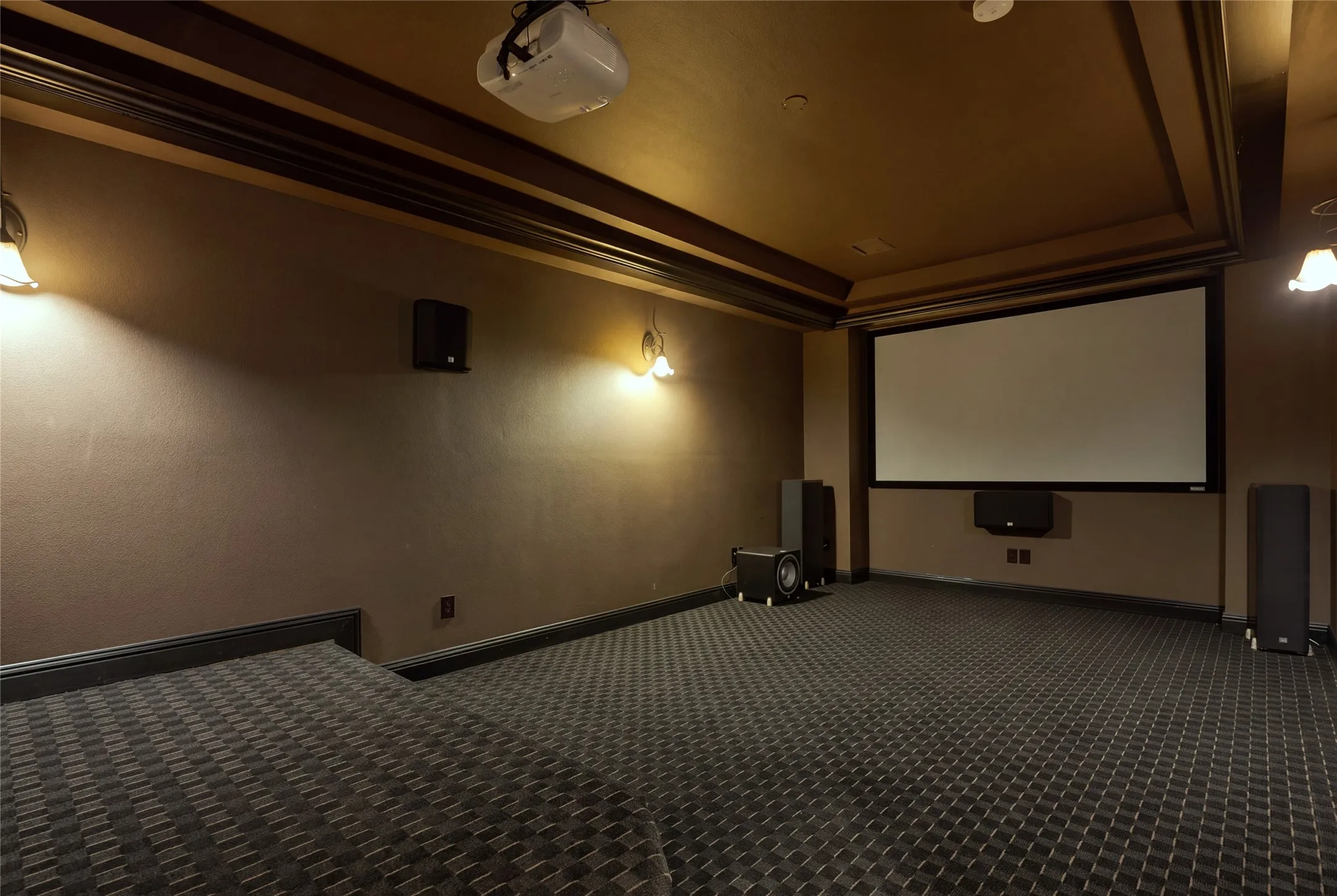 Dedicated media room featuring a large projection screen, projector, and integrated sound system