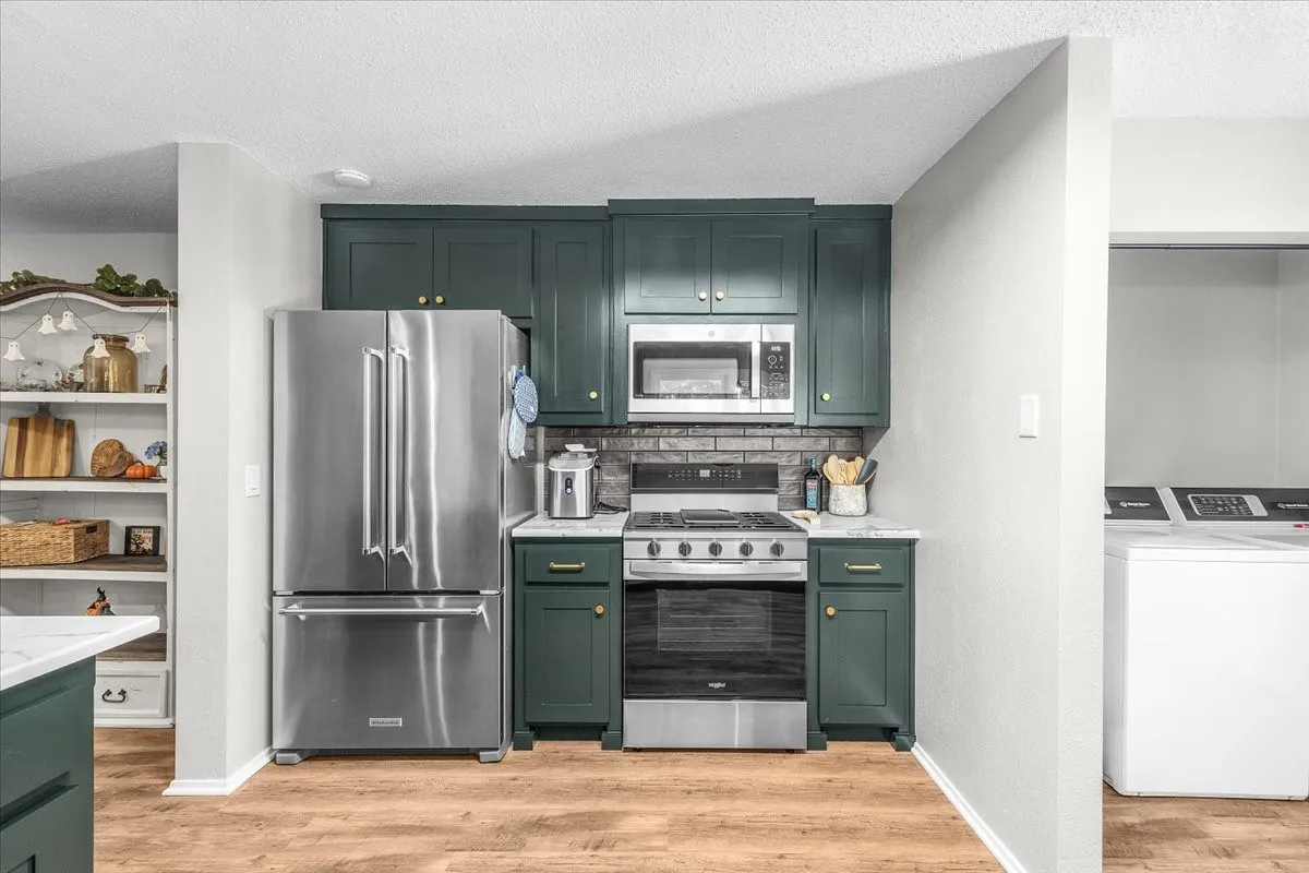 New cabinetry, wood-finish flooring, stainless steel gas range, and quartz countertops