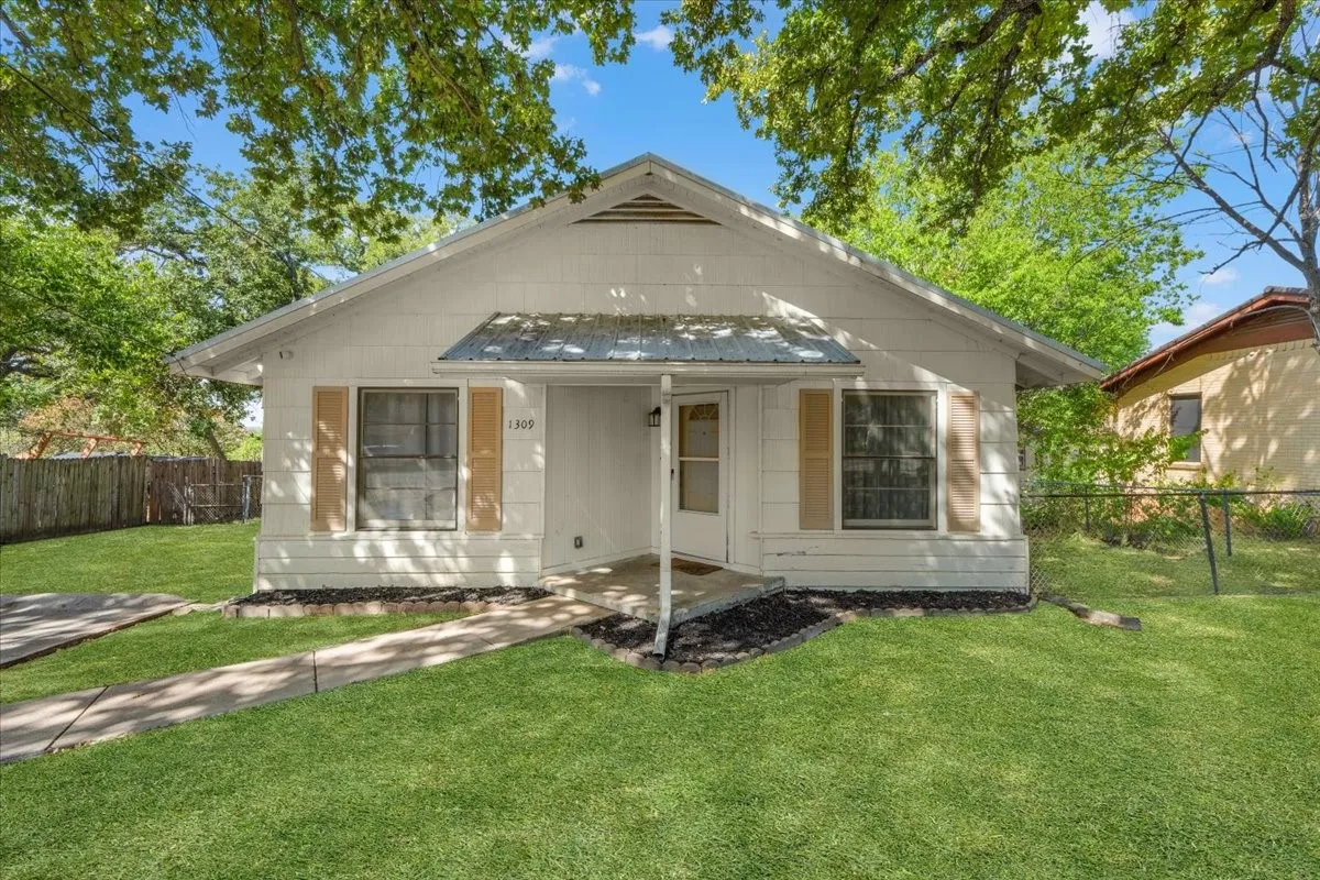 White exterior with a gable roof, covered entry, and front porch
