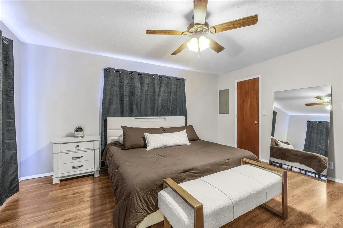 Wood-finish flooring throughout, complemented by a ceiling fan with integrated lighting