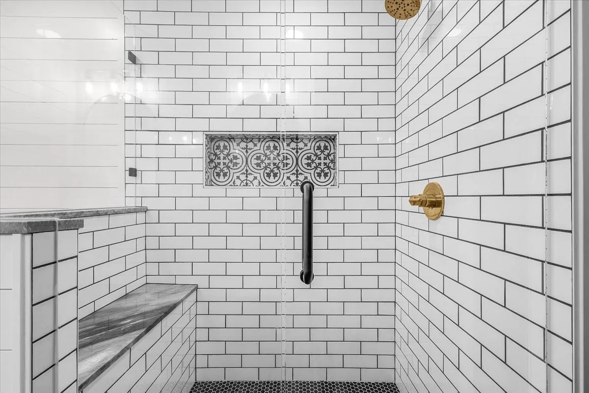 Subway tile shower with a built-in bench, bathing product shelf