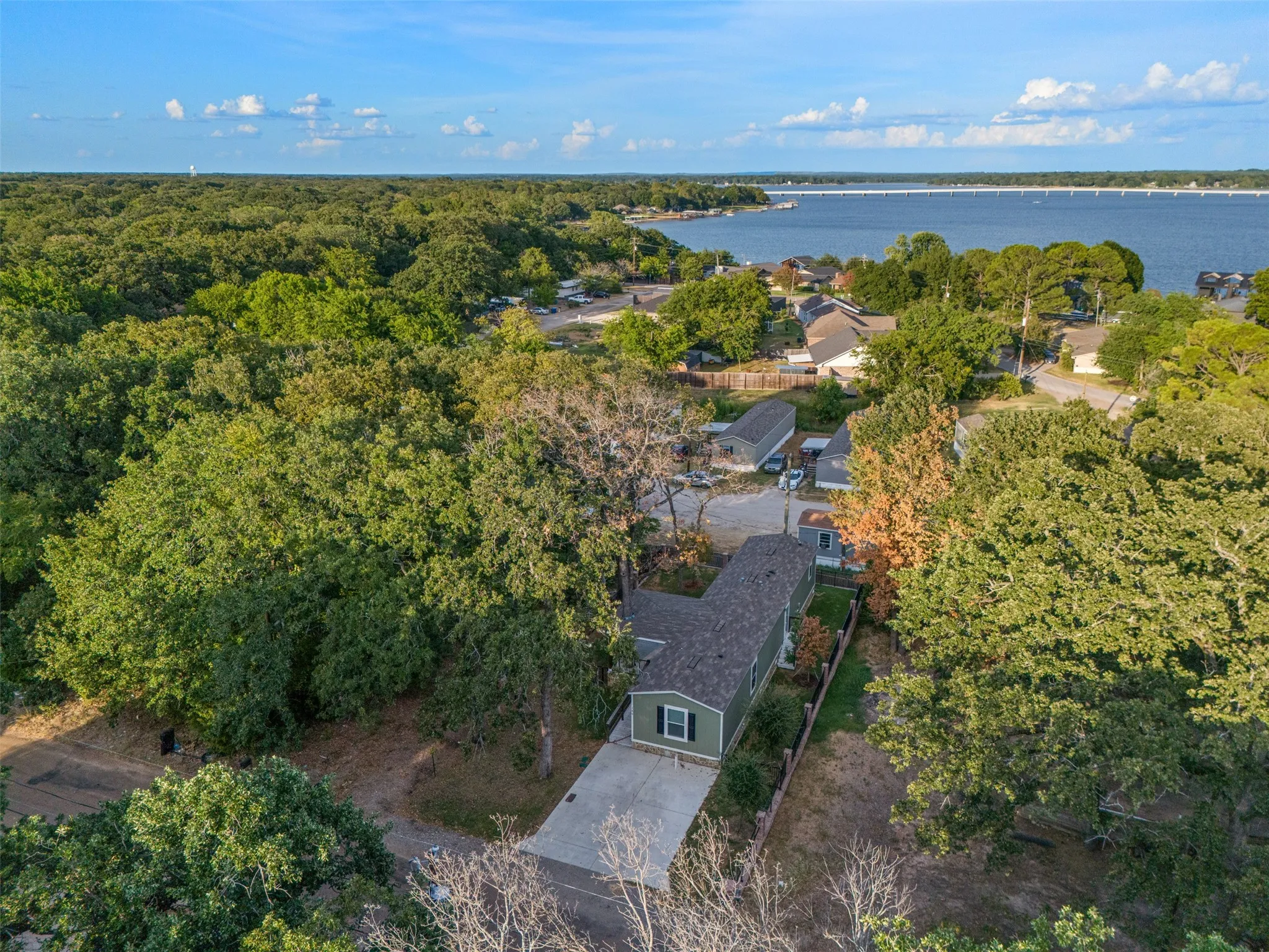 Waterfront community setting with mature trees and a paved driveway