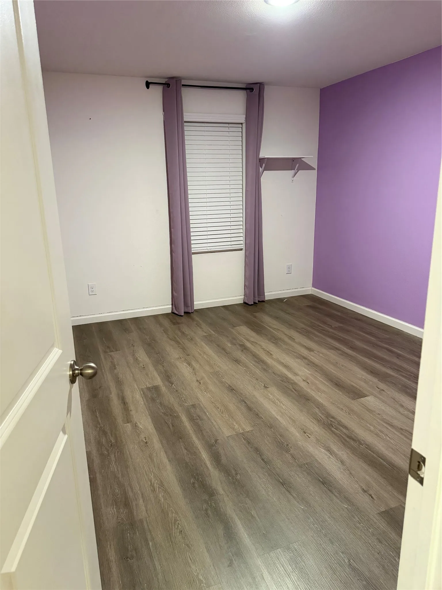 Wood-finish flooring with a flush-mounted ceiling light fixture