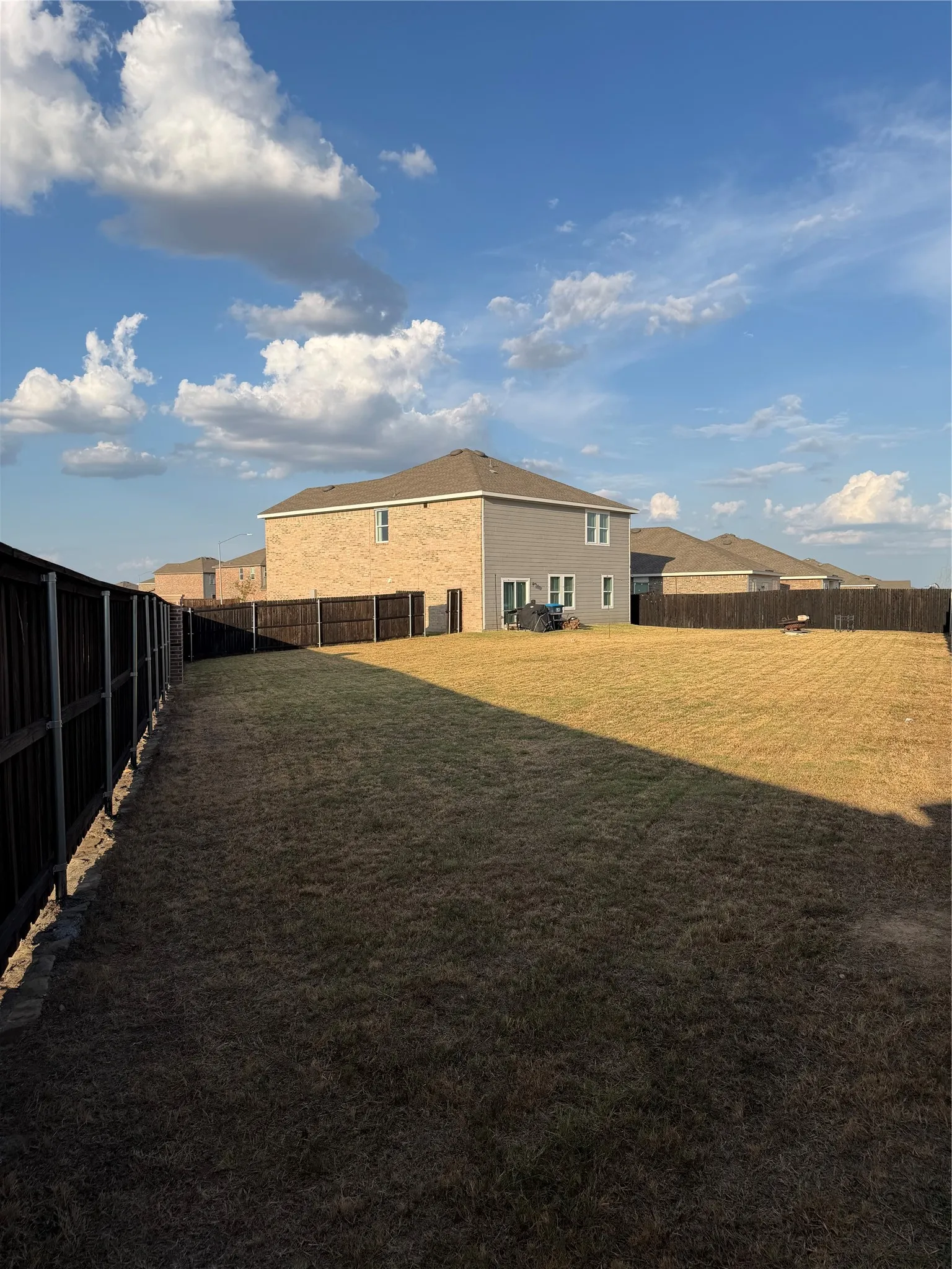 Expansive fenced backyard with a grass lawn