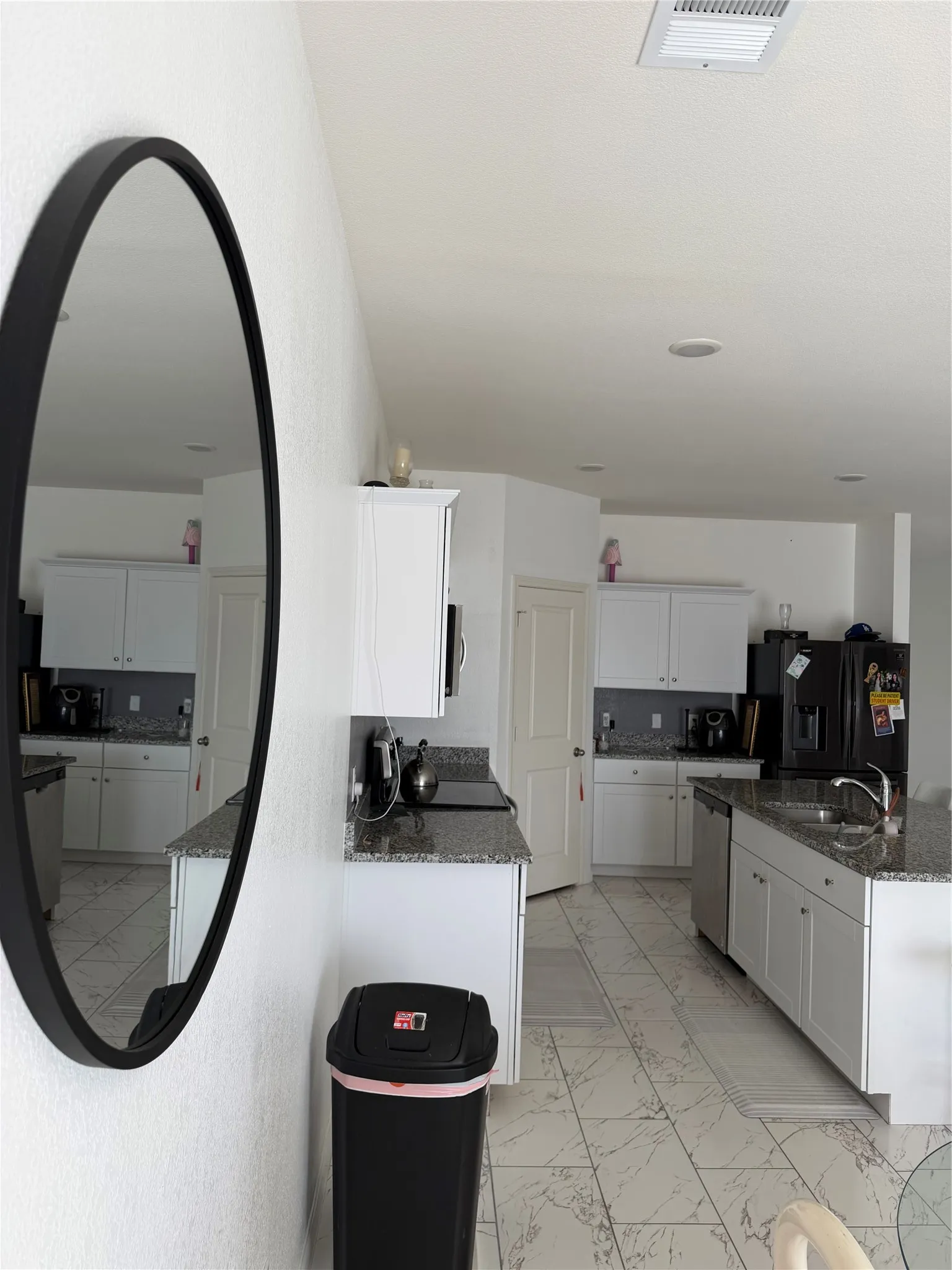 Kitchen featuring white cabinetry, granite-style countertops, stainless steel sink, and tile flooring