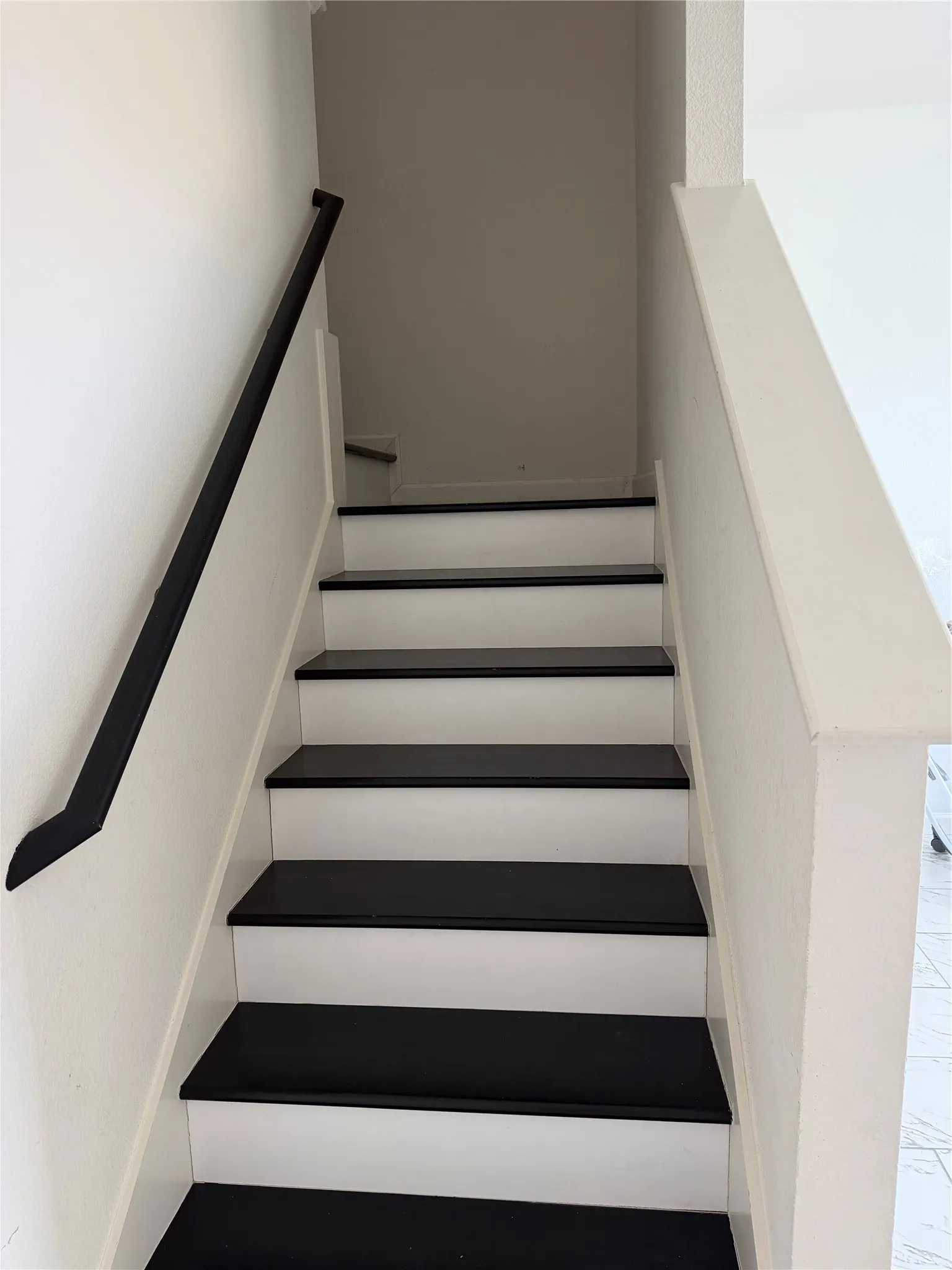 Staircase featuring dark treads and white risers
