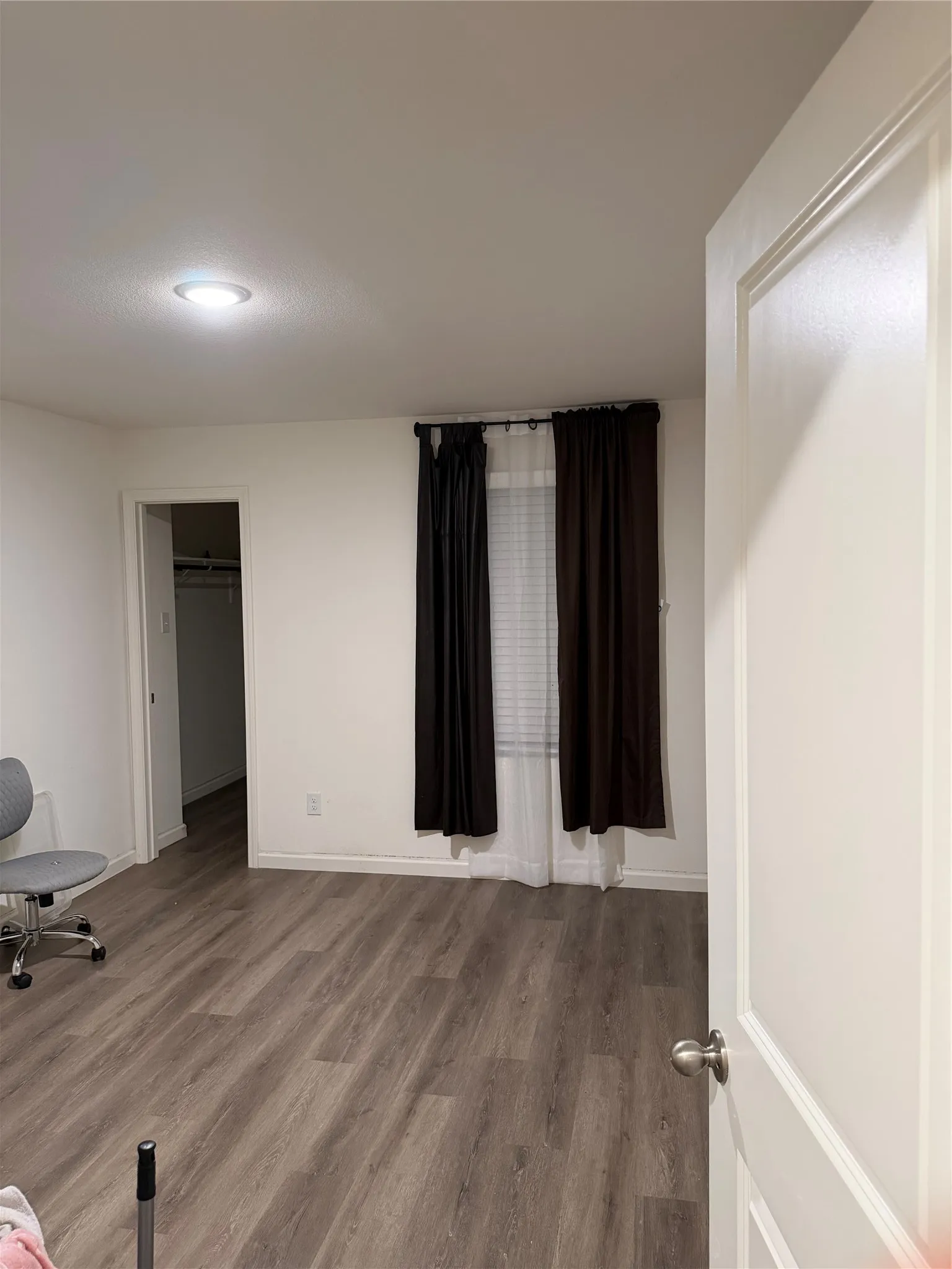 Recessed ceiling lighting, wood-finish flooring, and white interior doors
