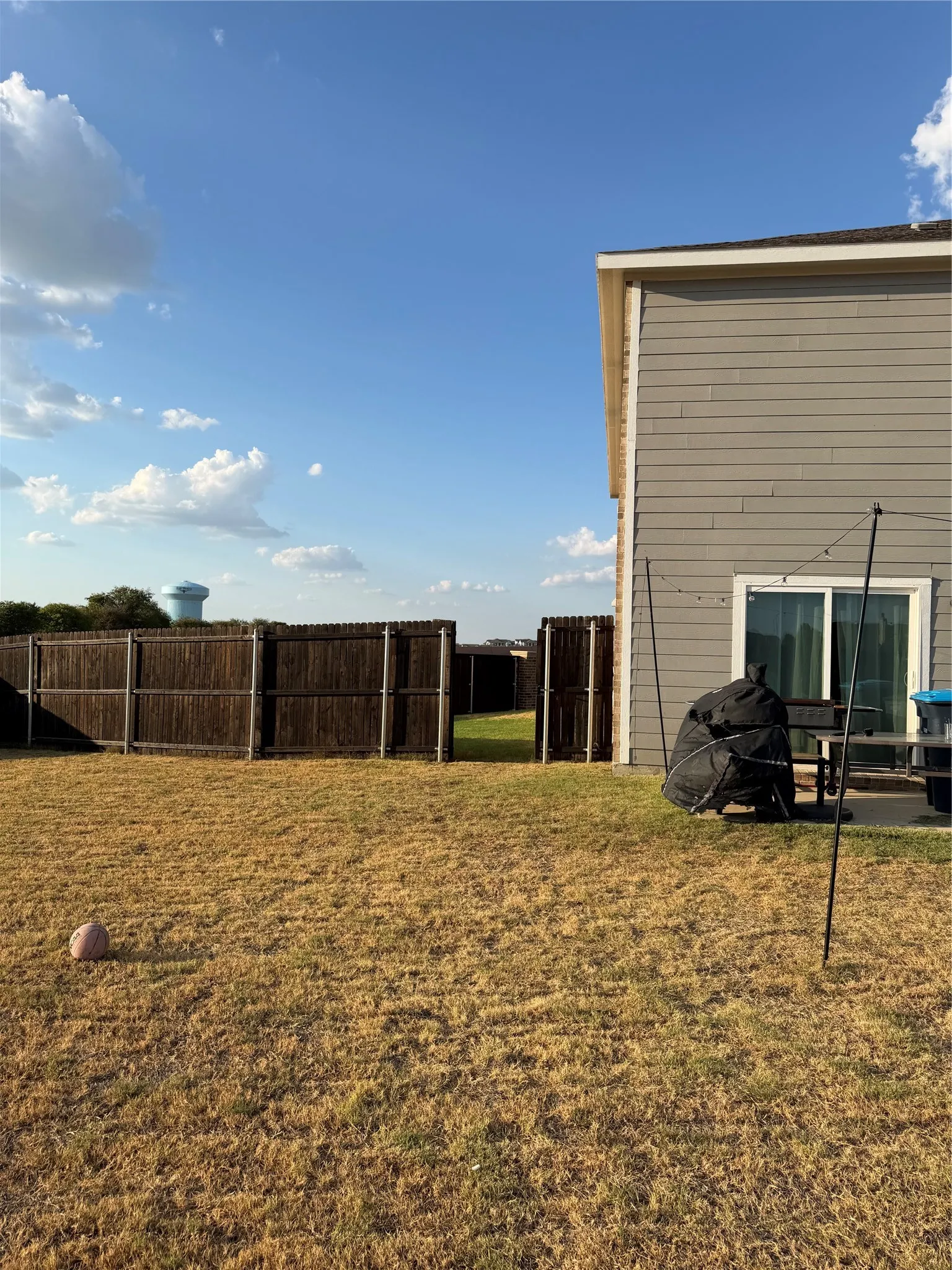 Rear exterior with horizontal siding, sliding glass door, and fenced perimeter