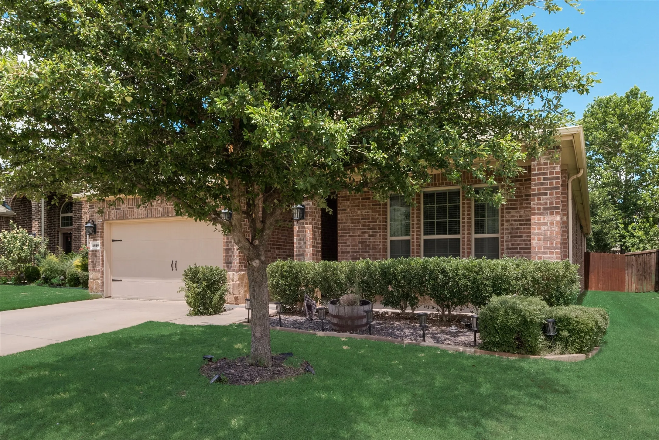 Obstructed view of property with a garage and a front lawn