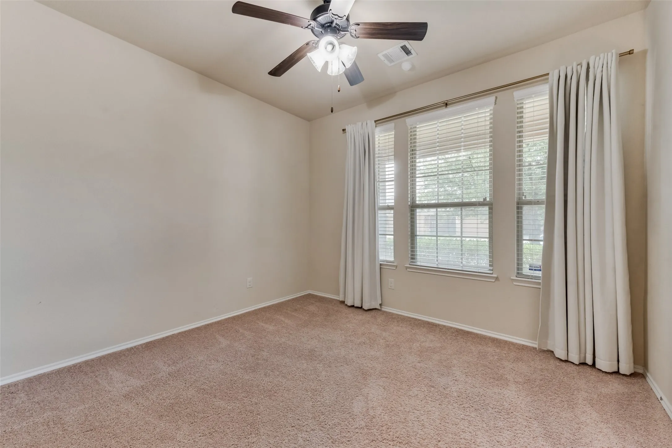 Spare room with light carpet and ceiling fan