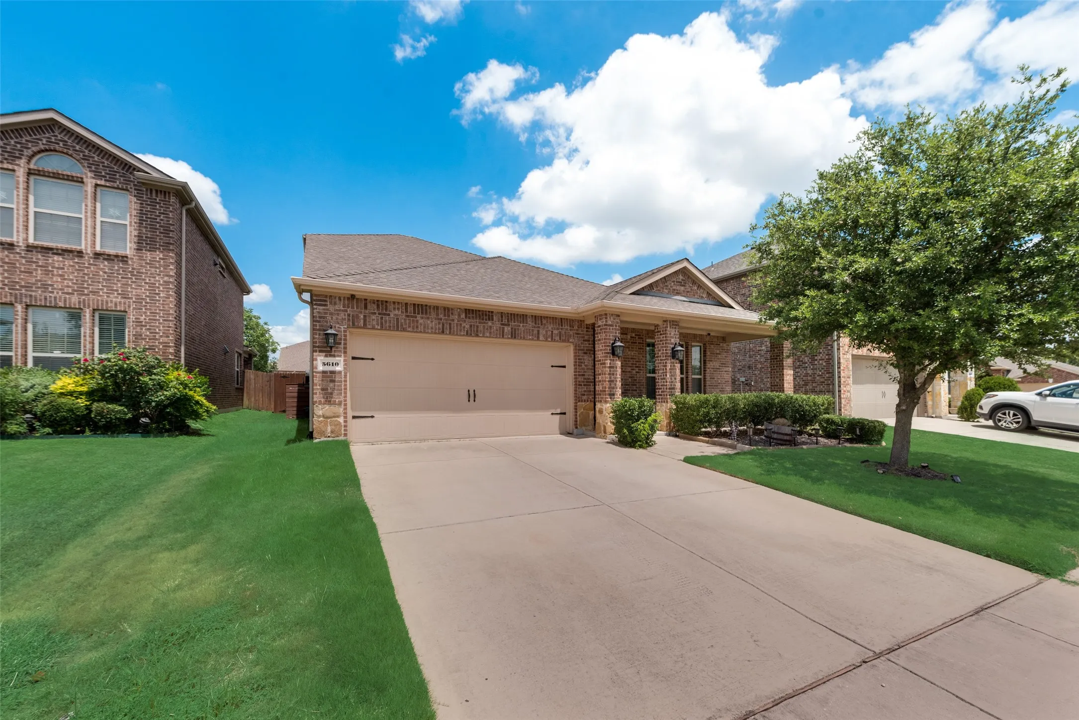 View of front of property featuring a garage and a front lawn