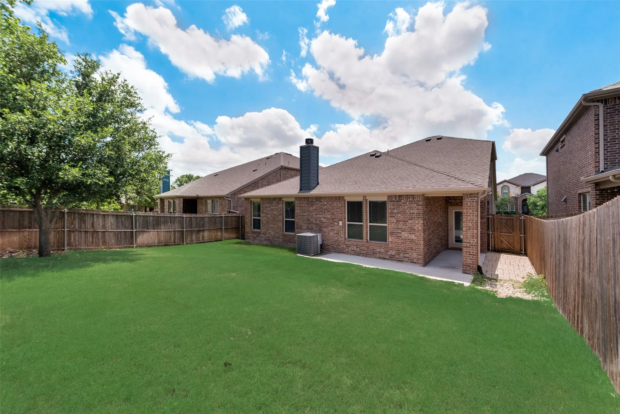 Rear view of property with a patio, central AC, and a yard