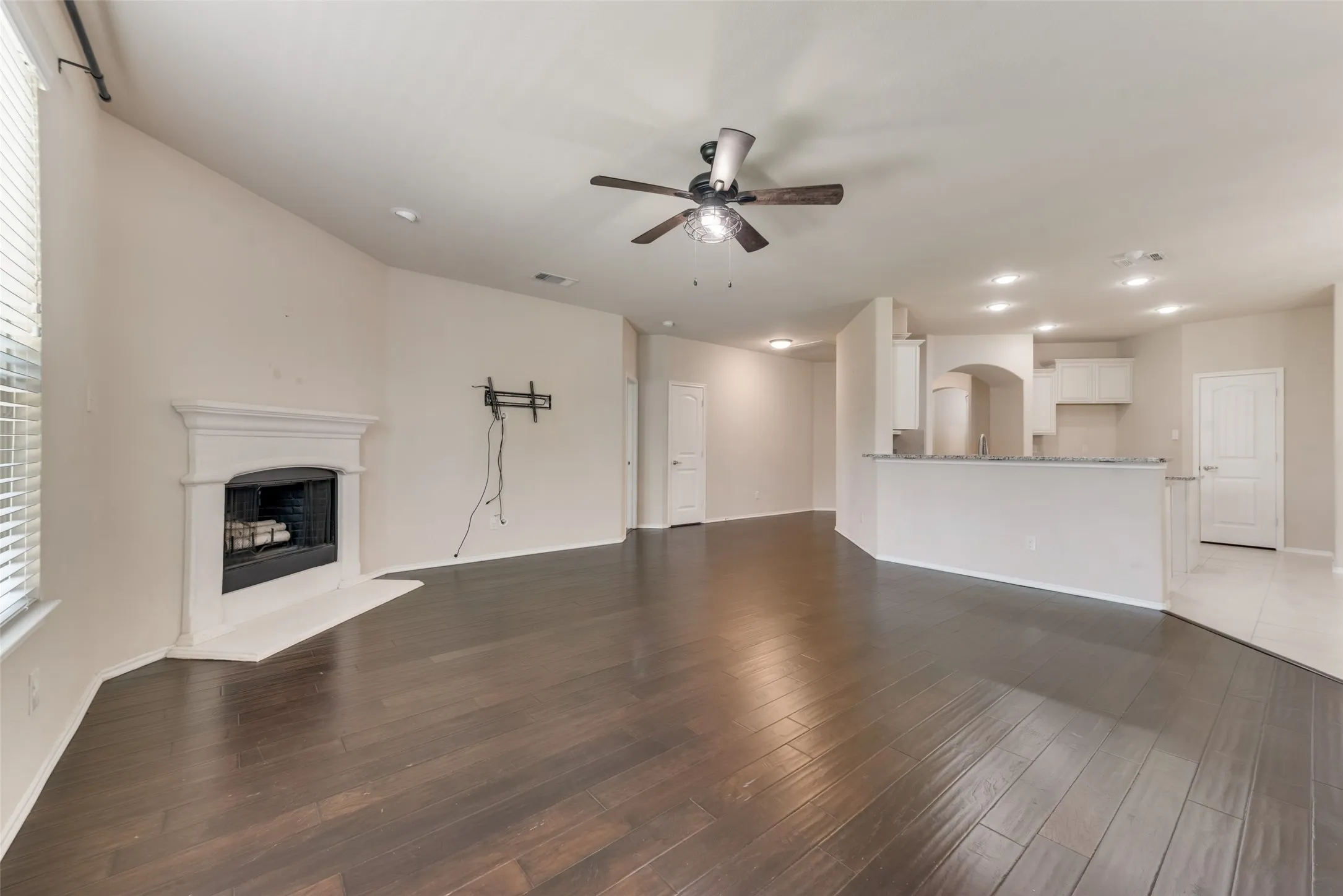 Unfurnished living room with ceiling fan and wood-type flooring