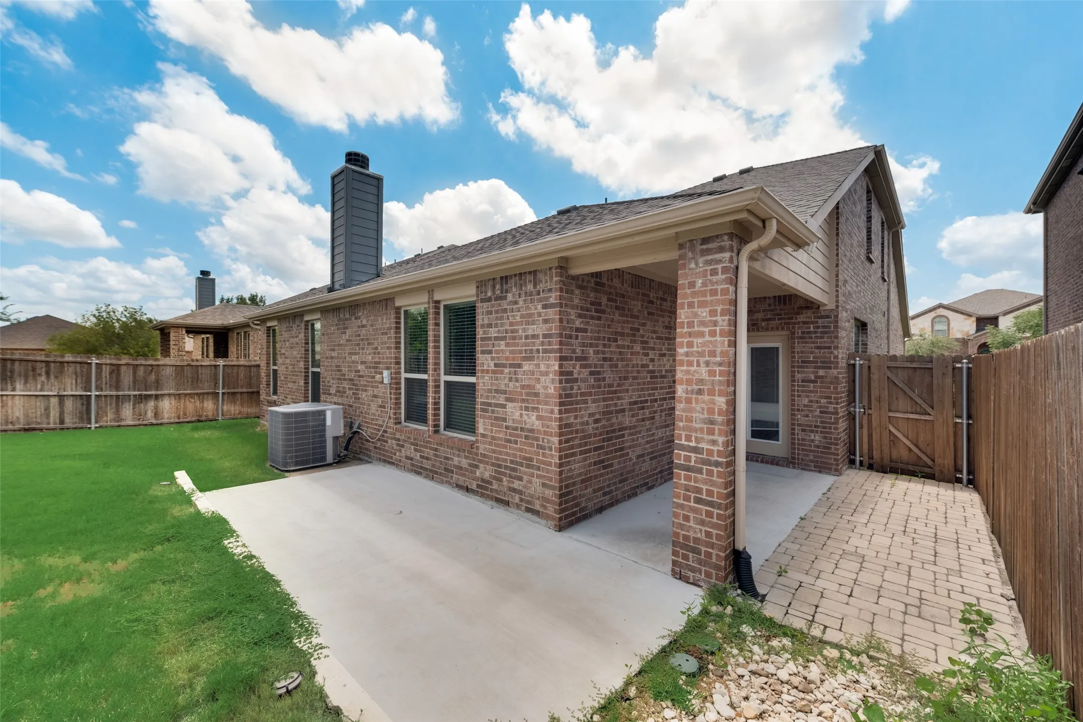 Back of property with a patio area, a lawn, and central AC unit