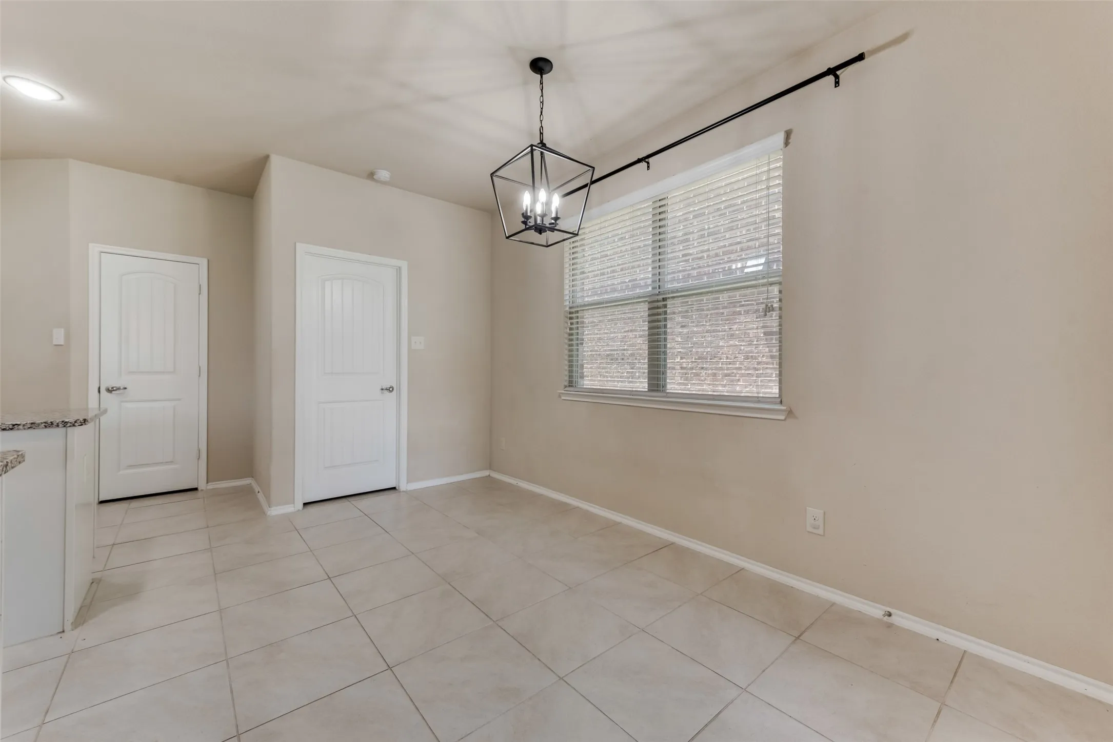 Unfurnished dining area with a notable chandelier and light tile patterned floors