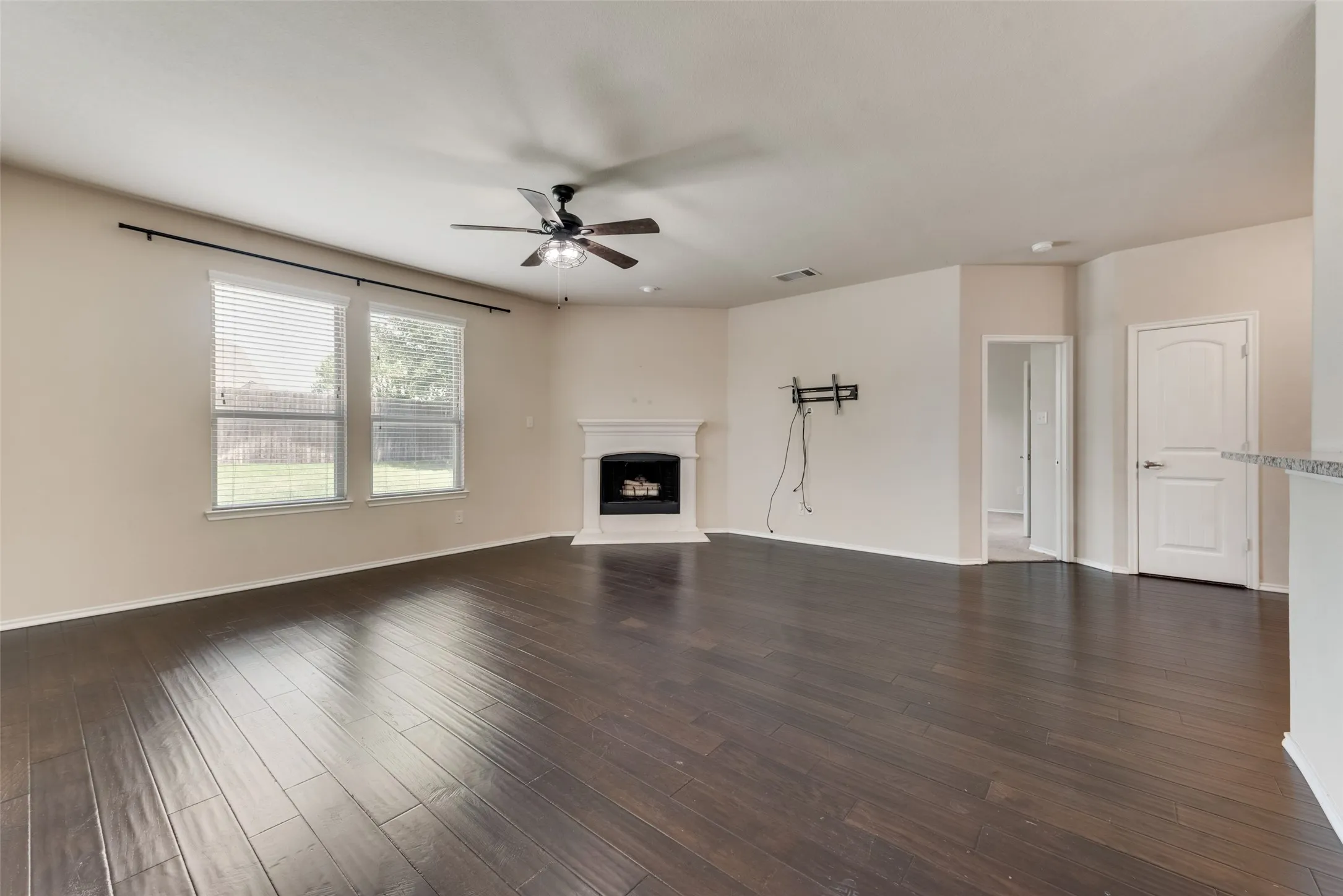 Unfurnished living room with wood-type flooring and ceiling fan