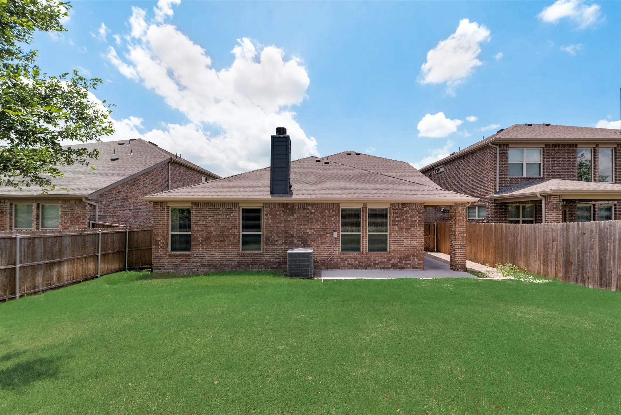 Rear view of house featuring central air condition unit, a lawn, and a patio area