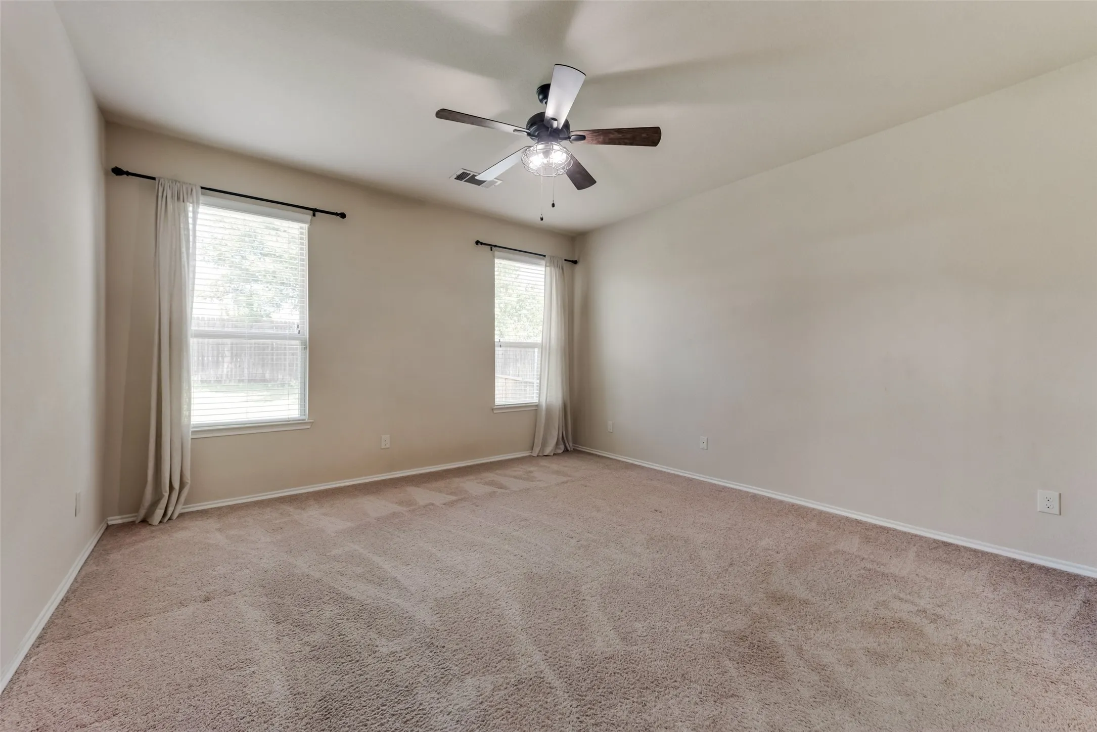 Carpeted empty room with ceiling fan