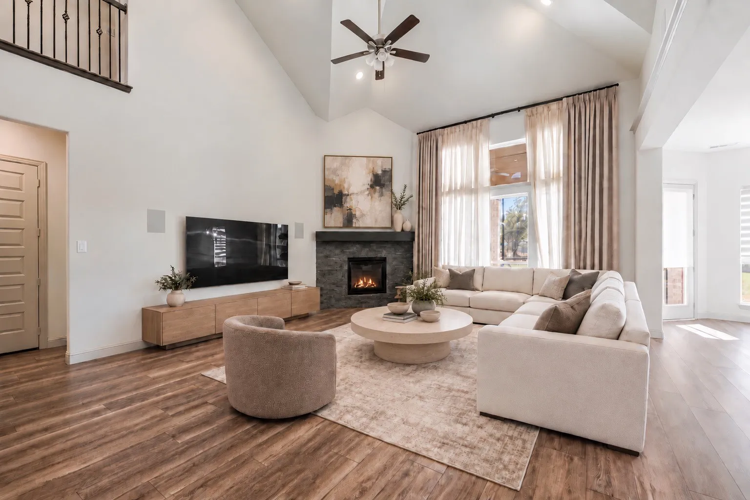 Vaulted ceiling, stone-clad fireplace with hearth, wood-finish flooring, two-story windows with drapes, and an open-concept layout   -staging with AI