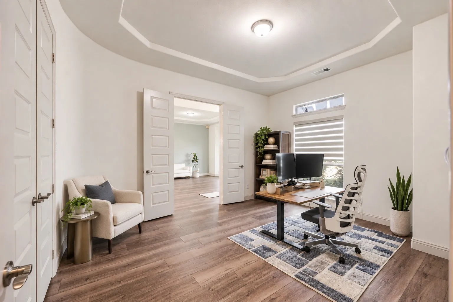 Tray ceiling with recessed lighting,  -wood-finish flooring, and double doors -staging with AI