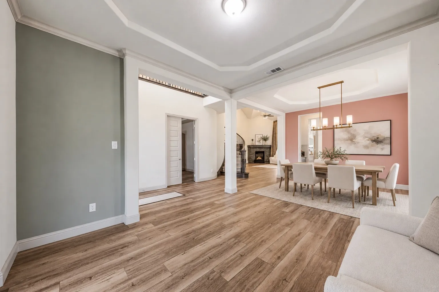 Wood-finish flooring throughout, tray ceiling with recessed lighting, and a chandelier in the dining area-  -staging with AI